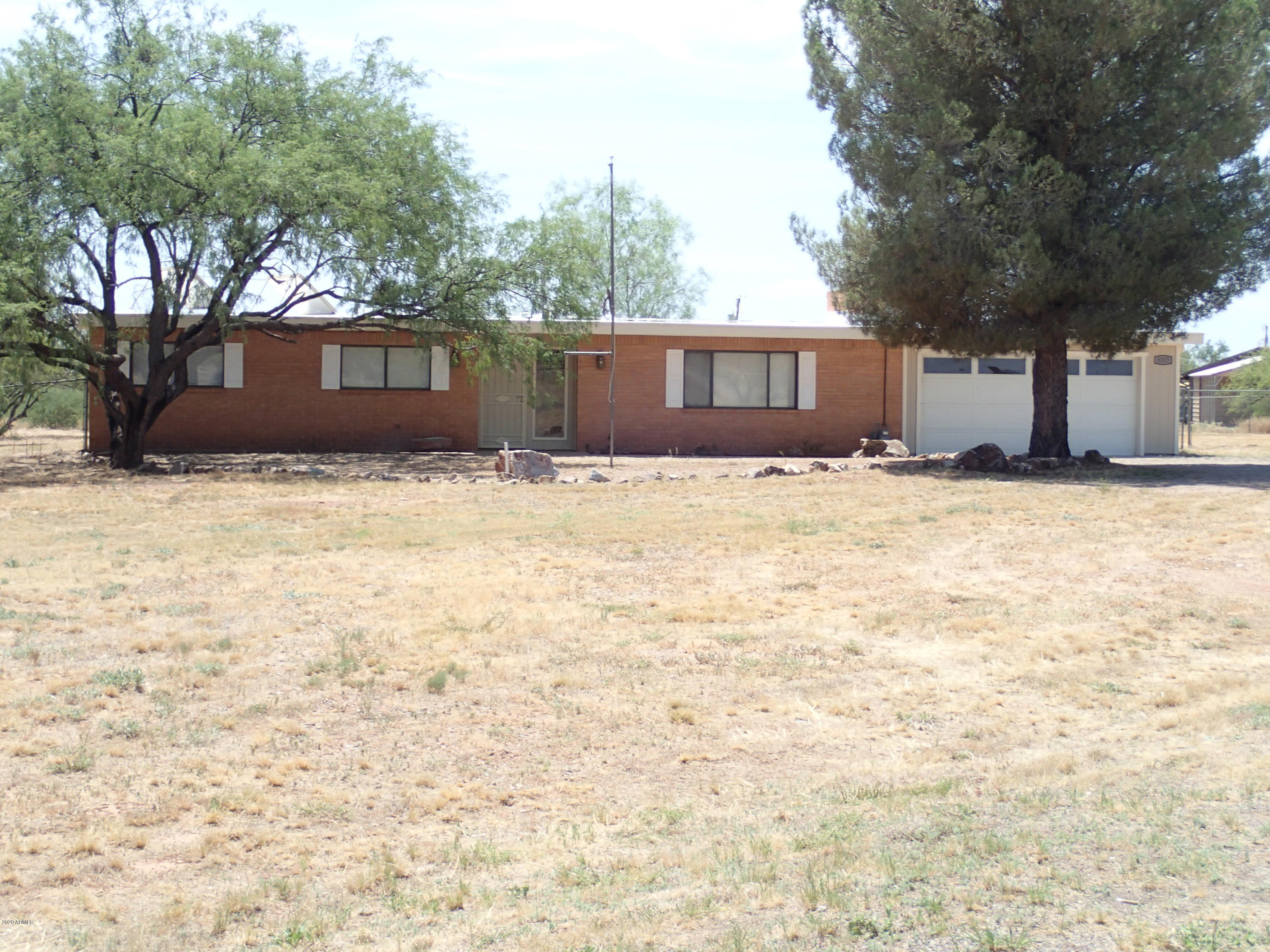 4 Bedroom Brick Home on 2 Acres off Paved Road--10 minutes to town!! This 4br, 2ba, 2 car garage (w/work space) is  almost 1900sqft  mostly Fenced, plus large shed and several gate entrances has alot to offer. NO CARPET. Wood Laminate in  All rooms,  Tile in Kitchen and Bathrooms. Tiled  Additional Recreation Room off Kitchen. Wonderfully updated Kitchen with Granite countertops  and newer SS Appliances. Wood Fireplace in Living Room. Newer Light and Plumbing Fixtures. Walk-In Tiled Shower with seat in MBR. Walk-In Closet with Exterior door from MBR. Solar Tube skylights makes this home bright and light with ALOT of room. Acreage is fenced, covered patio with Mtn Views. Must See--Won't last!!