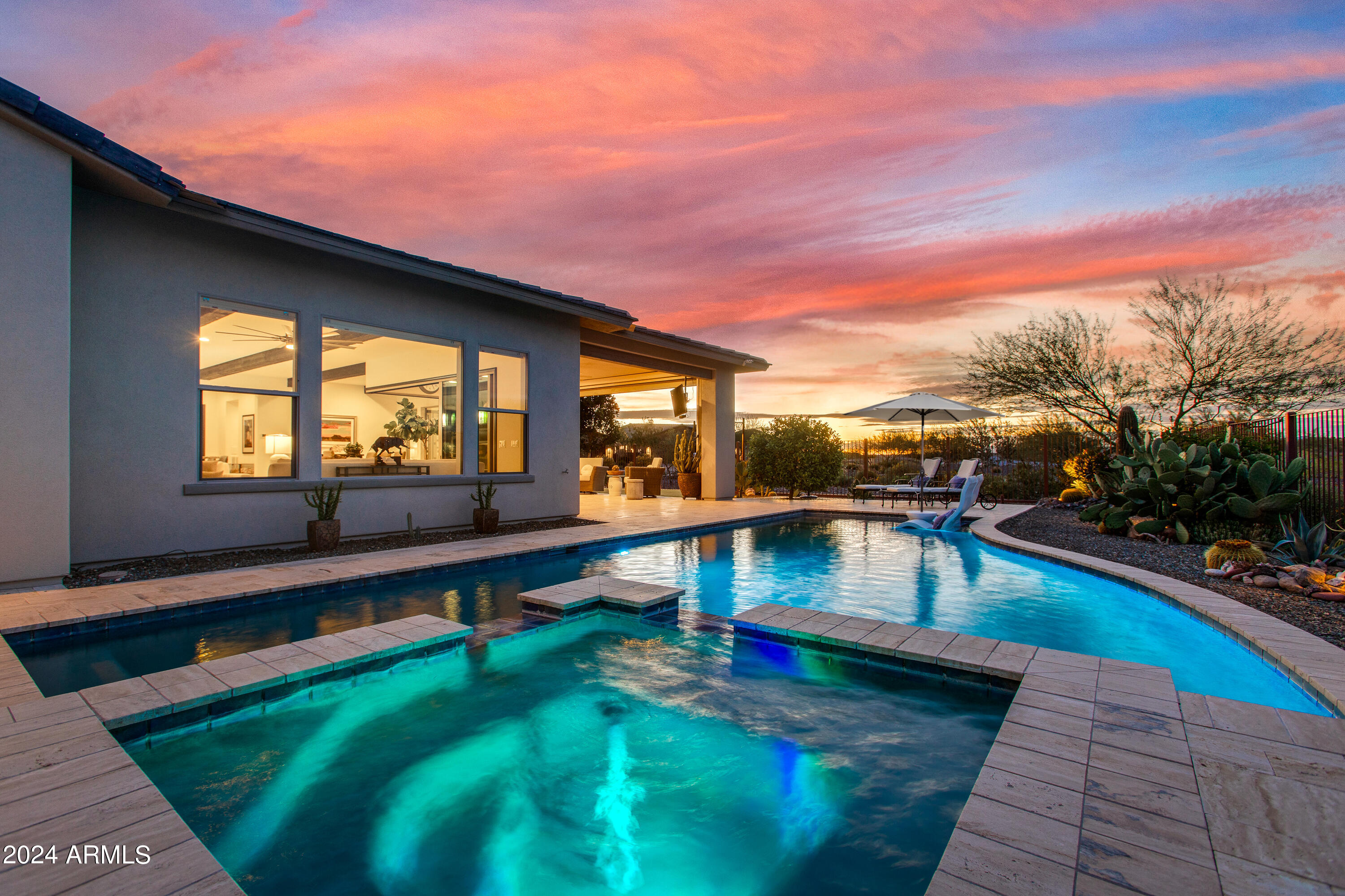 Exceptional Latigo model at Wickenburg Ranch on one of the highest elevation homesites. Private front courtyard w/ pergola, wood-burning fireplace & custom water feature creates a stunning entry to guest casita w/ independent HVAC, mini-fridge, walk-in closet & private bath. Panoramic mountain views & lush desert landscape through corner sliding glass extend living to covered patio w/ travertine, pool & spa--surrounded by HOA-maintained open space for privacy. Guest suite w/ ensuite & direct outdoor access. Primary w/ dual walk-in closets, freestanding tub, glass shower & split vanities. Den w/ built-in bar adds flexible entertaining space. Gourmet kitchen w/ GE Monogram appliances, custom cabinetry & large island. 3-car tandem garage w/ EV, R/O, central vac & mini spilt.