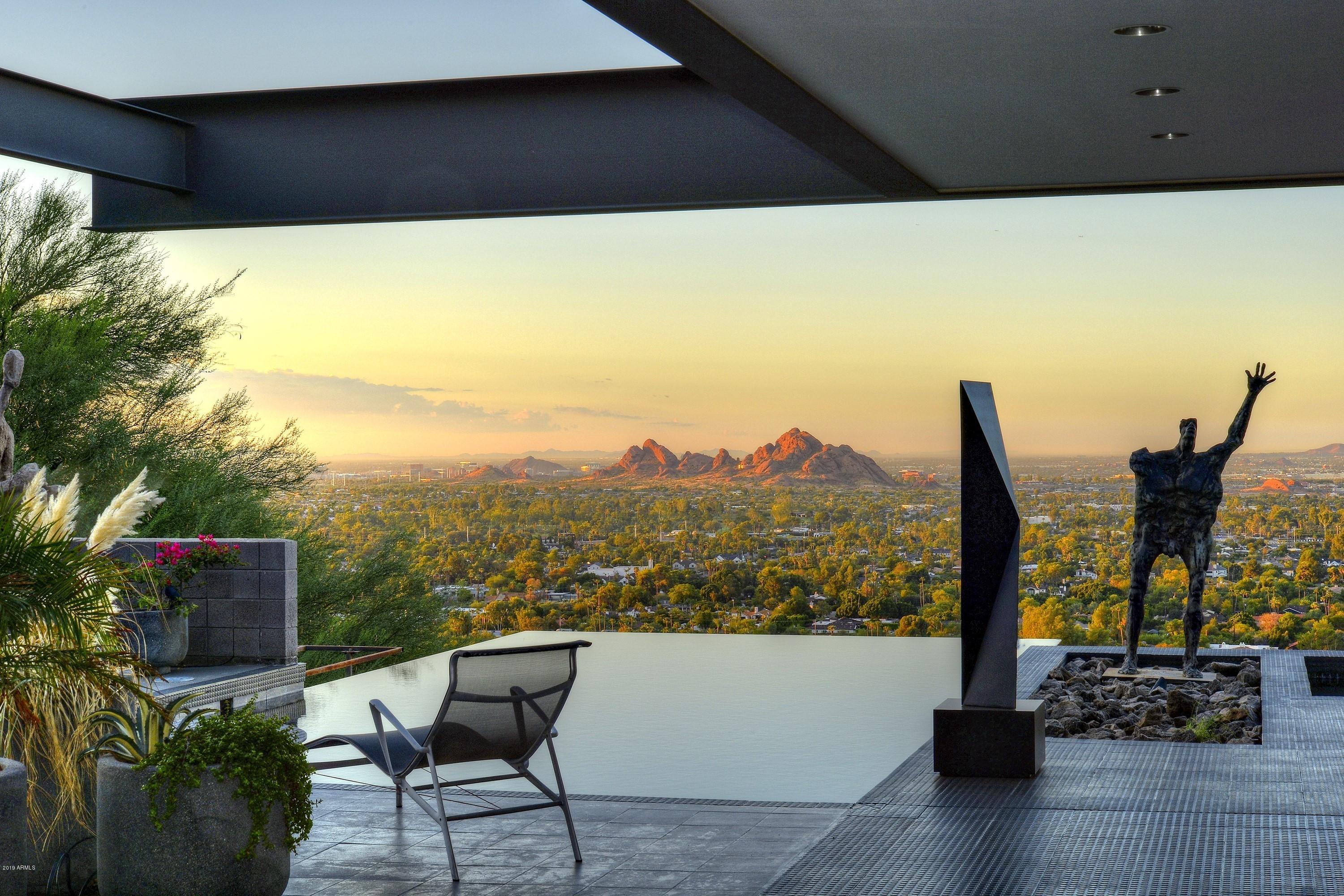 An important piece of art.  Extraordinary architectural masterpiece, perfectly positioned high on Camelback Mountain, with awe-inspiring views, and gallery walls for displaying art.  This amazing home will take your breath away, and presents an incredible and rare opportunity for the fortunate buyer. Designed by world renowned architect Michael Johnson, and dramatically positioned on Camelback Mountain, the home masterfully reveals prime views from each interior space, including the glass sided elevator. For those who appreciate fine design and unmatched views, you will have found your new home.