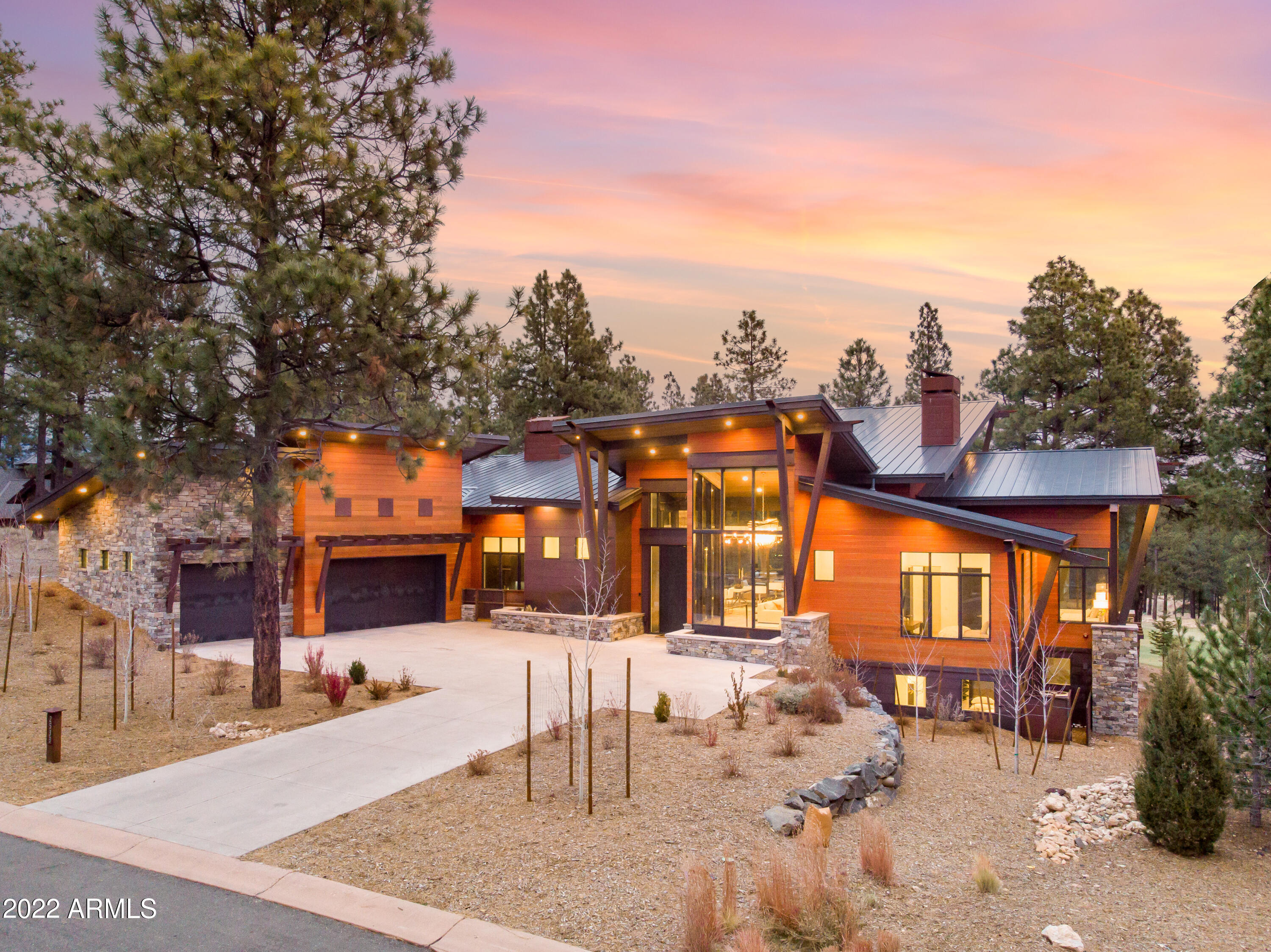 Start planning for Summer 2023 with this one of a kind fully furnished turnkey architectural show stopper. Overlooking the 18th fairway, this 4,512 sq. ft. 4 bedroom, 4 bath home is a contemporary custom masterpiece. The home was designed with floor-to-ceiling windows and multiple expansive sliding doors to take advantage of the golf course views while creating the ultimate indoor/outdoor living experience. 

Enjoy the beautiful Flagstaff weather by opening the multiple stackable slider doors to the elevated patio overlooking the golf course. This patio is perfect for entertaining friends and family with numerous seating areas, a built-in BBQ, beverage fridge, bar seating, and a built-in gas-fire table. The central living area blends kitchen, dining, and living into one space and includes extensive use of reclaimed wood, steel beams, along with metal and glass finishes. A custom tongue and groove ceiling, large wet bar, sunken entertaining space perfect for a billiards table, and a floor-to-ceiling stone gas fireplace with an expansive seating hearth, custom shelving, and a stone finish highlighting the massive great room. 

A beautiful floor-to-ceiling wine cellar is also located just off the kitchen and is backed by black glass tiles which reflect the custom pendant light fixtures.  A wet bar highlighted with beverage drawers, an ice maker, and custom floating steel shelves. In addition, the kitchen includes a large center island with seating, Cambrian Black countertops with a satin finish, a large butler's pantry with a refrigerator, built-in microwave, and a custom steel barn door. 

The primary suite on the main level provides separate access to the patio and includes walk-in closets with custom shelving, dual floating vanities, a large soaking tub, and a walk-in shower. 

There are also 2 additional guest suites on the main level, a second primary suite on the lower level, and a family room. The second primary suite includes a walk-in shower room adjacent to an extra-large soaking tub and dual floating vanities. 

The home offers automated surround sound and electric window coverings throughout. Other features include a 3-car garage, a separate laundry room with two stackable washers and dryers, custom shelving and sink, heated driveway, and custom wood and metal exterior siding.

Don't miss this unique opportunity to own one of Pine Canyon's most exquisite, fully turnkey custom homes.