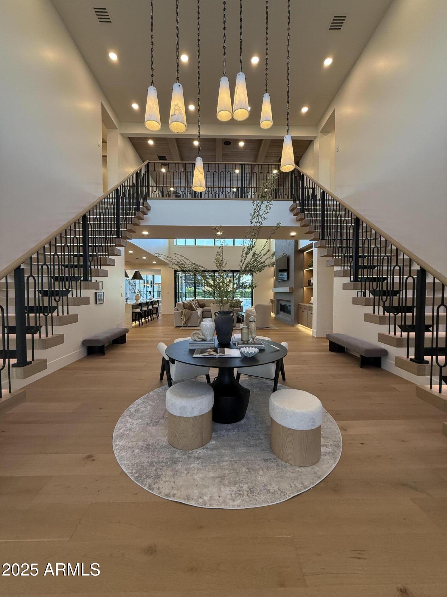 Welcome to Landmark at Somerset—Gilbert's most coveted neighborhood—where timeless elegance and modern design converge. This show-stopping residence sits on a fully manicured half-acre lot, offering the ultimate in privacy, sophistication, and location.

Soaring 21-foot ceilings and floating double staircases create a dramatic first impression, while warm white oak finishes and Taj Mahal quartzite surfaces provide a stunning contrast of natural beauty and refined luxury. Designed for wellness and indulgence, the home includes a resort-style negative edge pool & private gym with a custom sauna, making everyday feel like a retreat.

This home is the pinnacle of East Valley luxury.
