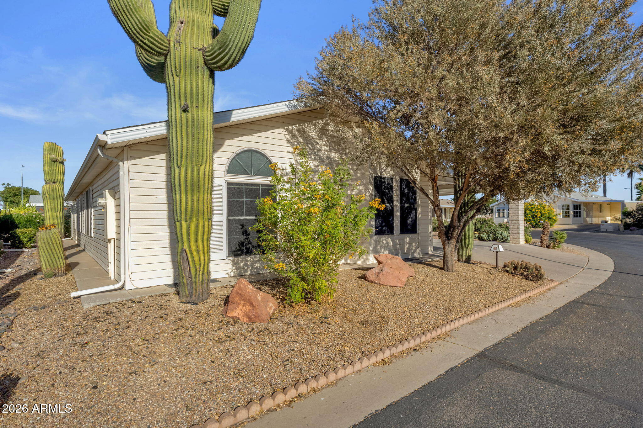 Start your mornings in a quiet, resort-style community and end your day in comfort; welcome to Las Palmas Grand! Located on a premium corner lot in this highly desirable 24-hr guard-gated community, this beautifully maintained home offers the perfect blend of space and easy living. The split floor plan features 2 bedrooms, 2 baths, and a versatile den; ideal for a home office, hobby space, or guests. The spacious primary includes an updated ensuite with a tiled, handicap-accessible shower & double vanity. Enjoy your morning coffee or evening unwind in the Arizona room with its own AC. Rare oversized laundry room w/ built-in cabinetry & utility sink. Complete with a covered 2-car carport and separate workshop. Resort-style amenities:pools, fitness center, pickleball & social calendar!