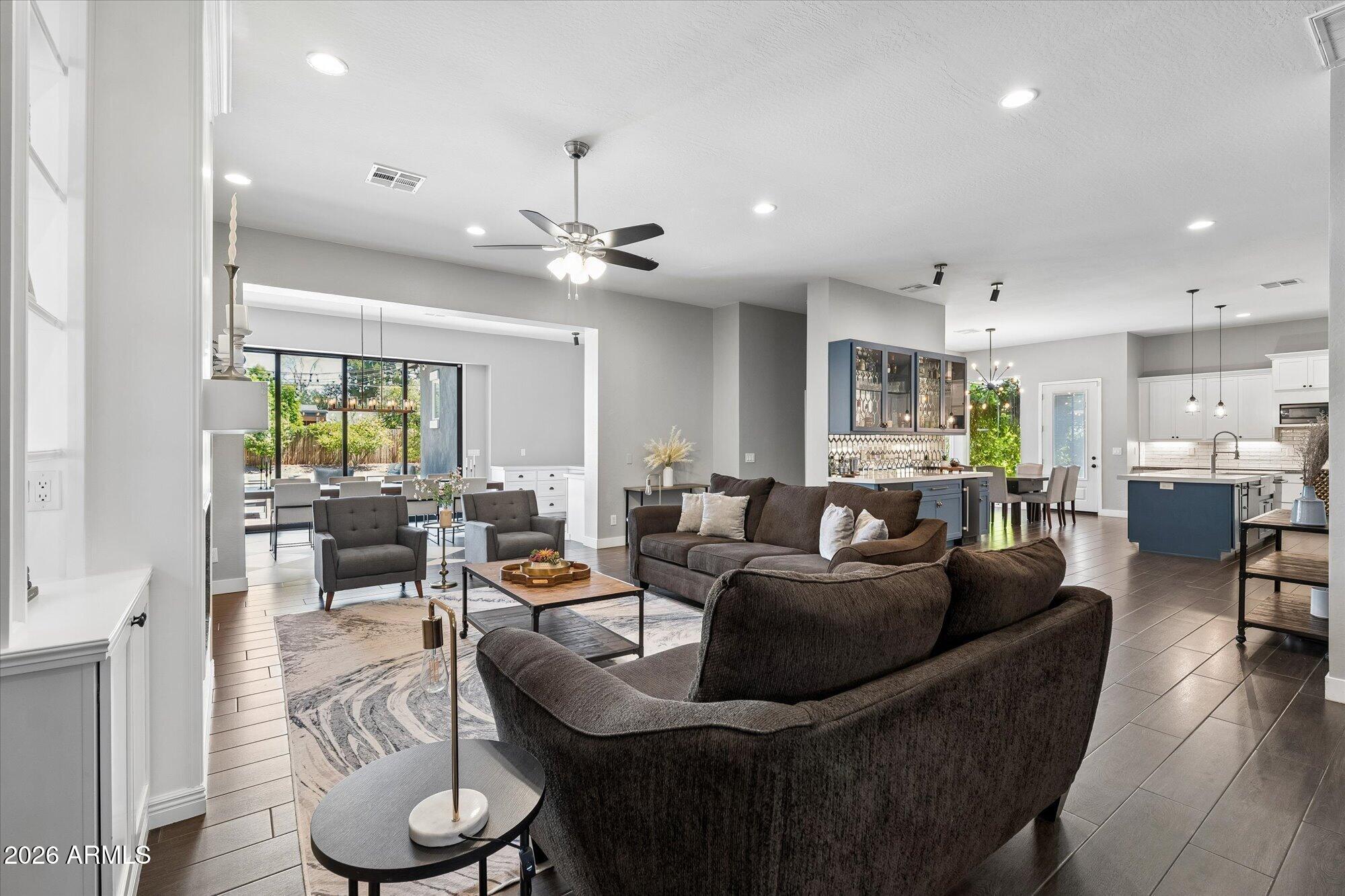Rarely does a home offer this much space, flexibility, and privacy in one of Phoenix's most desirable locations. Set on an impressive 18,000 sqft lot just moments from Arcadia Lite's acclaimed restaurants, coffee shops, boutiques, and entertainment, this fully remodeled 7 bed, 5 bath residence offers 4,072 sqft designed to adapt to the way you live. Reimagined in 2017, the home blends expansive gathering spaces with thoughtful functionality, highlighted by soaring 12-foot ceilings and dramatic floor-to-ceiling windows that flood the main living area with natural light and create a seamless connection to the outdoors. At the heart of the home, the kitchen was built for both everyday living and hosting on a grand scale, featuring a large quartz island, farmhouse sink, two dishwashers, and a dedicated bar complete with an ice maker. The open layout allows conversation and connection to flow effortlessly between the kitchen, dining, and living spaces, making everything from family dinners to large celebrations feel natural and inviting. Multiple bedroom configurations provide incredible flexibility for growing households, guests, multigenerational living, or dedicated office space.

Situated away from the main living areas, the private primary suite offers a peaceful retreat and a welcome sense of separation from the rest of the home. Outside, the property continues to impress with a backyard designed to be enjoyed year-round. Gather around the gas firepit, enjoy outdoor dining under the Arizona sky, or watch the kids explore the backyard jungle gym. A gated driveway enhances privacy and creates an estate-like arrival experience rarely found in this area.

The detached workshop adds another layer of versatility and could easily serve as a future casita, fitness studio, media room, creative workspace, or golf simulator. Car enthusiasts will appreciate the oversized garage with additional height for a vehicle lift. Combining scale, privacy, flexibility, and an unbeatable location near some of Phoenix's most popular destinations, this is a home that evolves with your lifestyle and offers possibilities that are increasingly hard to find. Experience it in person and discover everything this exceptional property has to offer!