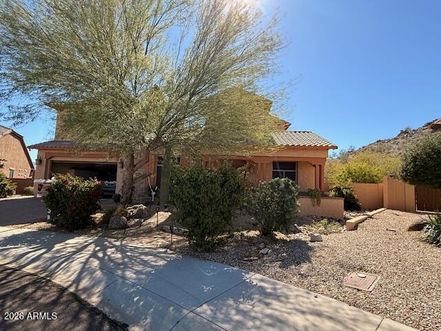 This highly exclusive custom entertainers dream home is truly one of a kind and is the only floor plan of this model available in Estrella Mountain Ranch having even won an award for most unique model. Enter through a paved patio into a grand foyer with attached dining room and sitting room with gas fireplace. Past that enter into the gourmet chef's kitchen with high end appliances nestled off of a enclosed outdoor courtyard with 2 way fireplace and sitting area. Also located on the main floor is the family room, library and eat in kitchen area.  Second floor boasts Master Bedroom/bathroom, loft, 3 bedrooms, 2 bathrooms and laundry room.  Enjoy expansive Estrella Views on your own private mountain in this complete custom backyard oasis!!  To many amenities to list, must see!