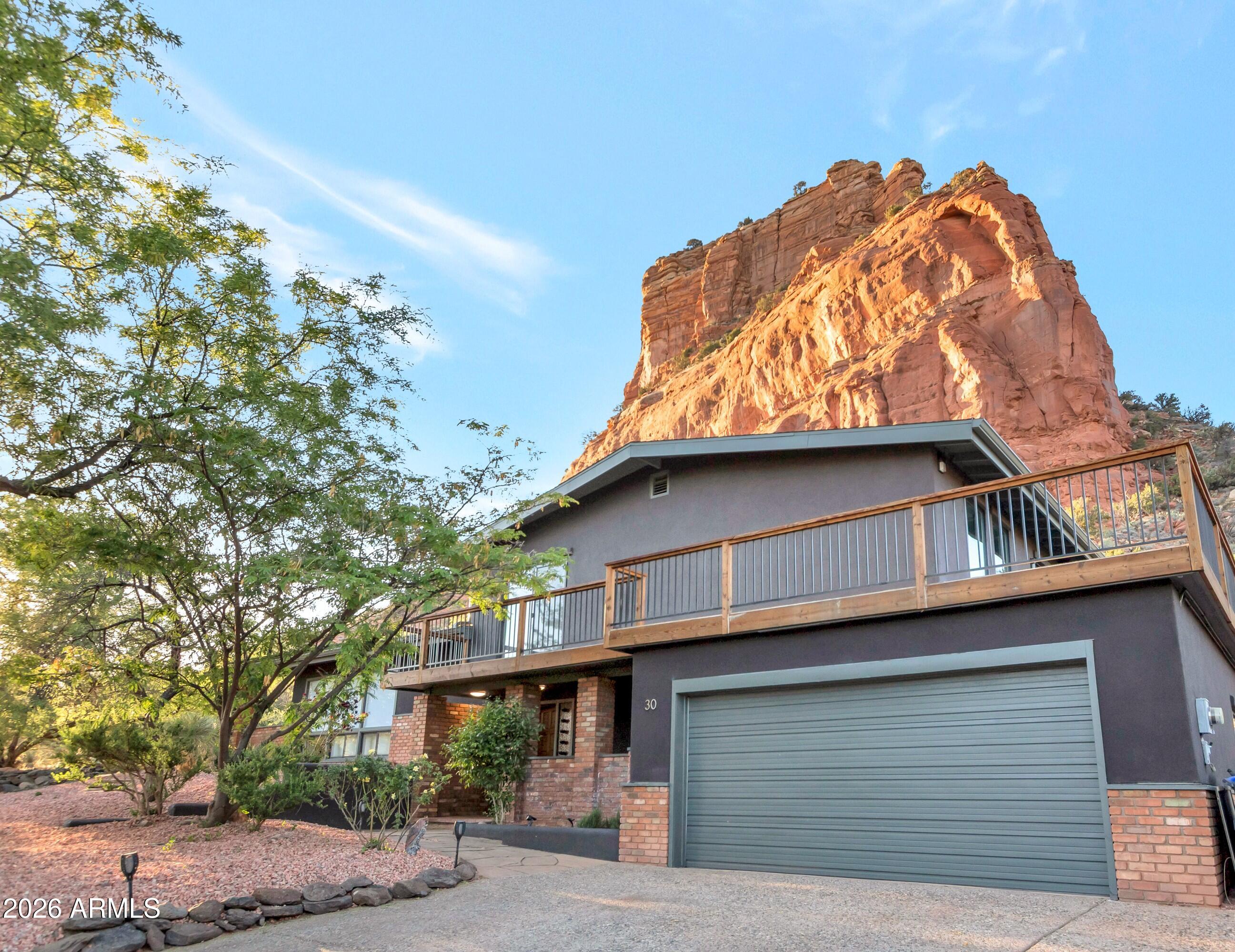 Set against the dramatic backdrop of the National Forest, 30 Beaver Creek Drive offers the kind of Sedona experience buyers often come here to find: privacy, red rock scenery, indoor-outdoor living, and a peaceful setting that feels removed from everyday life while still being close to Village amenities.
Designed as a contemporary Sedona retreat, second home, or flexible lifestyle/investment property, this residence captures breathtaking red rock vistas from nearly every room. Expansive decking and intimate outdoor spaces create natural gathering areas for morning coffee, sunset dining, quiet reflection, or evenings beneath Sedona's star-filled skies. A private two-person spa adds to the retreat-like atmosphere, offering a tranquil place to unwind after a day of hiking, exploring, or hosting guests.
Inside, the home has been thoughtfully updated to enhance both comfort and flexibility. The reimagined kitchen serves as the heart of the home, featuring modern cabinetry, striking custom epoxy countertops, and a skylight that fills the space with natural light. Large-format tile flooring flows through key living areas, while a sleek electric fireplace adds warmth and ambiance to the contemporary interior.



The flexible floor plan is especially well suited for today's evolving lifestyle needs. Newly improved third and fourth bedrooms expand the home's versatility, including a fourth bedroom with built-in office cabinetry that works beautifully for remote work, creative space, or guest accommodations. An additional finished space converted from a former workshop behind the garage provides even more flexibility as a private office, studio, wellness space, guest retreat, or owner's storage area.



The property has also benefited from significant investments in major systems and exterior improvements, including a new HVAC system, tankless water heater, upgraded water line, smart thermostats, upgraded elastomeric exterior coating, new gutters, retaining wall improvements, and expanded decking. These updates support comfort, efficiency, and peace of mind for full-time residents, seasonal owners, or buyers seeking a lock-and-leave Sedona getaway.

Modern conveniences including leased solar panels, smart home features, and a Ring doorbell add efficiency and connectivity without compromising the home's relaxed and private atmosphere.



30 Beaver Creek is more than a traditional residence. It is a Sedona lifestyle property -- an inviting sanctuary where contemporary comfort, flexible living spaces, and the timeless beauty of the red rocks come together in one compelling retreat.