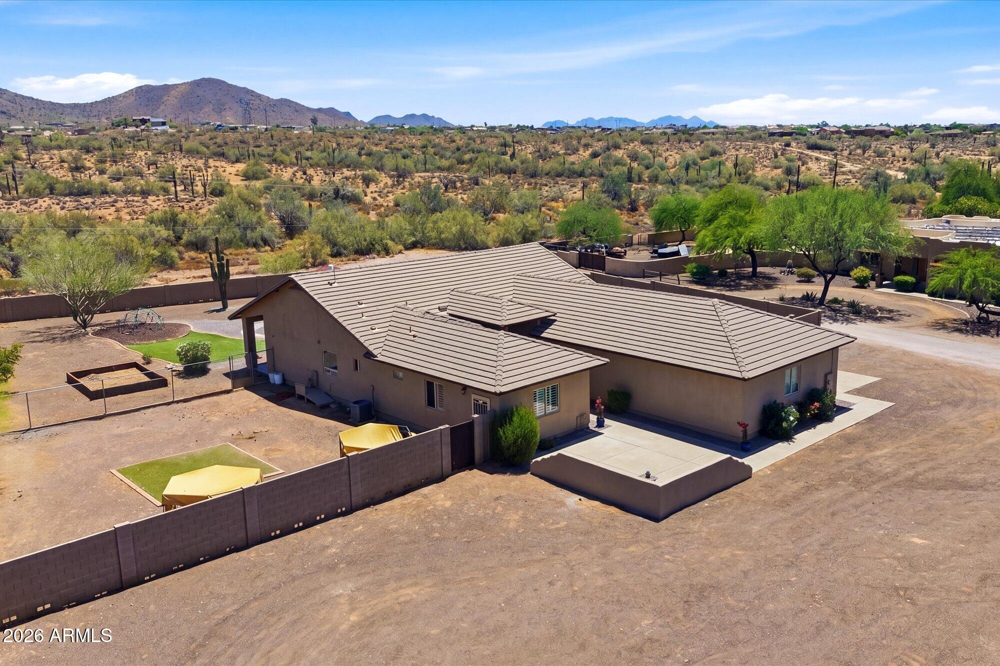 Experience true desert sanctuary living with the Arizona Preserve as your borrowed-backyard. Custom 4bedroom, single level ranch home located on private cul-de-sac, offers rare independence with 5-home well-share, no HOA, and a flat usable acre with room to live your lifestyle your way. Outside- a massive RV gate, covered outdoor kitchen with built-in BBQ, wood-burning fire pit & panoramic views. Inside- soaring vaulted ceilings & open-concept layout create an expansive living space. Kitchen features granite counters & pantry with seamless flow into dining & living spaces. Flexible 4th bedroom with custom cabinetry, sink, & private entrance works beautifully as a home office, studio, or workshop. Crisp desert evenings, a canopy of star & endless views -- where luxury meets desert charm.
