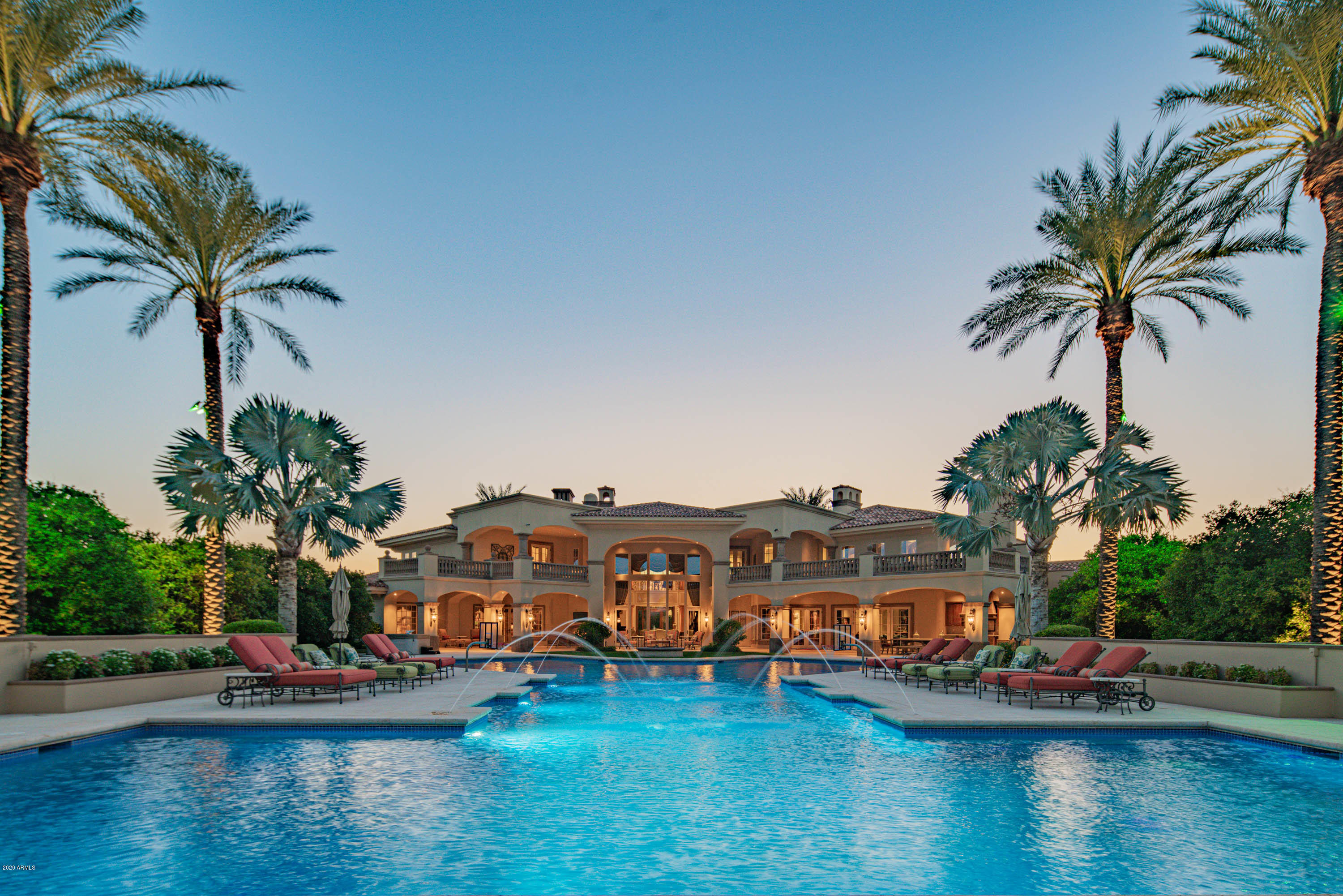 Mesa's most extraordinary estate, this idyllic 4.4-acre property encompasses a 5-bedroom main residence and guest house, set amidst a grove of 220 citrus trees. Setting the stage for the grandeur within is the gated, tree-lined motor court, leading to the spectacular entry hall with 13' glass/steel front door and 22' ceilings. Interiors showcase the highest quality finishes, including masterful woodwork, marble floors and stately columns. Features include a home theater, game room, office, 2 family rooms, 2 kitchens, formal dining and butler's pantry. Interiors segue seamlessly to the outdoors, featuring a resort-sized, saltwater pool, outdoor kitchen, putting green, playground, lush flat lawn and 5-car garage. The 1-bed,1.5-bath guest house features a kitchen, family room & 2 car garage.