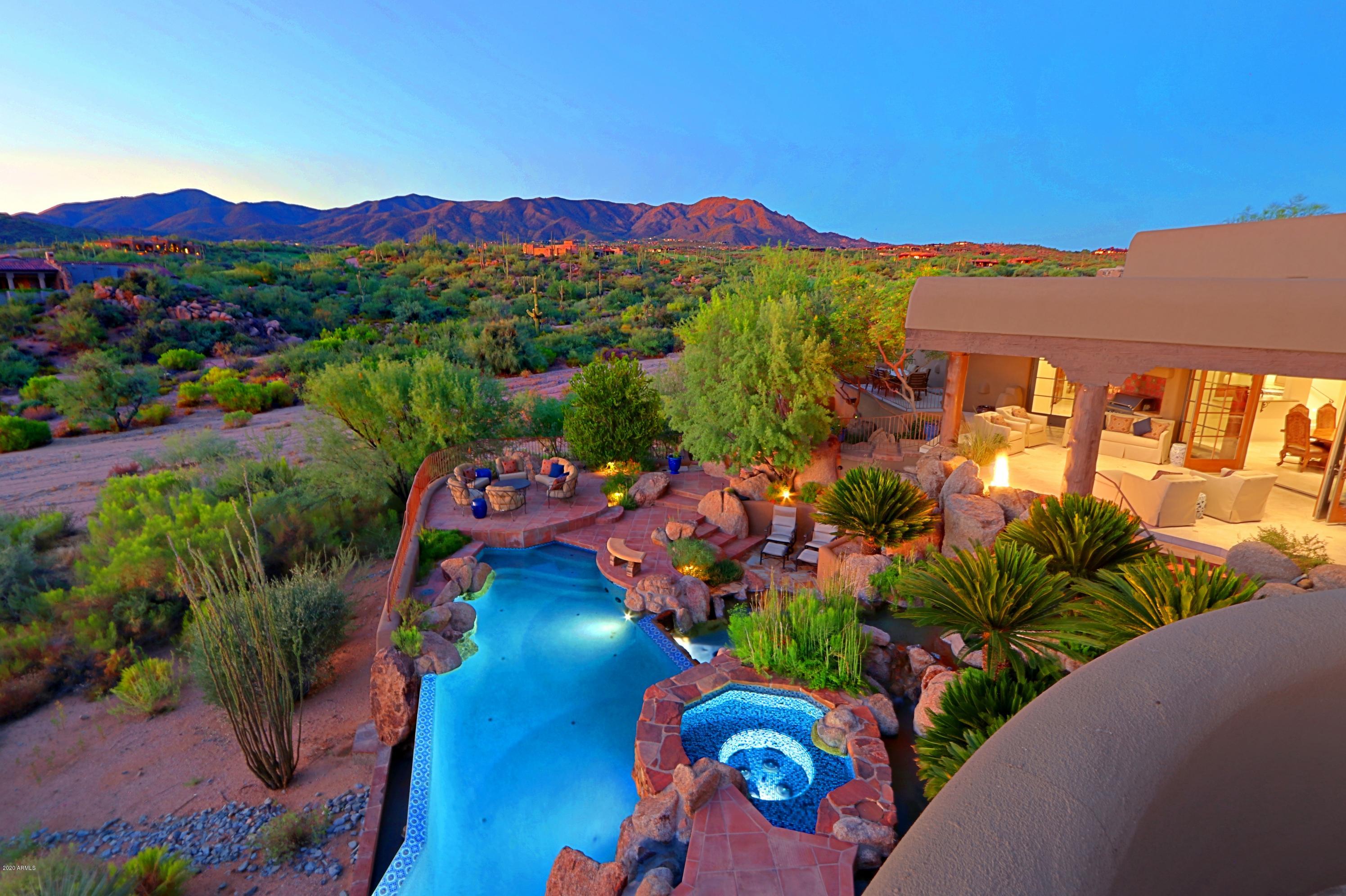 Dazzling Desert Mountain home mountain & golf course views!Exquisitely redesigned 2014 by Masters of the Southwest-architecture by Mark Candelaria & interior design by Isabel Candelaria-ASID award winner.Fluid indoor & outdoor living style & sensational views throughout.Outdoor oasis:infinity edge pool, wading pool & spa, fire pit, infrared heaters & built in BBQ.Great room:travertine, unique stone/wood fireplace, sculpted exposed beams, oversized wood glass doors.Expansive chef's kitchen:Sub Zero refrigerator, Viking dual ovens & commercial gas cooktop, leathered sea foam granite countertops & built in wine fridge.Large master retreat & spa like bath:soaker jetted tub & huge jetted shower.4/5 bed 5 ½ bath:private bath & patio every bedroom.Too many fabulous details to list.Must see home! This dazzling, one of a kind home is nestled between two of the six Jack Nicolaus signature golf courses  Chiricahua and Geronimo - in Desert Mountain! Glorious mountain and golf course views, an abundance of outdoor entertaining space, and the cultivated high end finishes you would expect from a residence of this caliber.

This Santa Fe style masterpiece was originally imagined and designed by the renown Allen Tafoya in 2003. This home was then exquisitely redesigned by two award winning Masters of the Southwest  featuring the brilliant and masterful architecture of Mark Candelaria, and fit and finish beautifully done under the creative guidance of Isabel Candelaria - ASID award winning interior designer of Earth and Images. A dream pairing that culminated in this unique home with the charm of old Arizona elegance, yet boasting all the most up to date amenities.

Your first steps inside immediately reward your senses with stunning views out to the fabulous backyard which is nothing short of majestic. Fluid indoor & outdoor living style with expansive patios setting the stage for a leisurely, luxurious lifestyle. Grand outdoor lagoon for all your entertaining and relaxation needs including an infinity edge pool, wading pool, spa and water features surrounded by exotic landscaping blending with the desert beyond. Outdoor open firepit, and infrared outdoor heaters to warm the skin and not your surroundings. A large built in BBQ area close to the kitchen, and so many gathering spaces for family and friends. A pure delight!

This breathtaking home is enhanced by a dramatic entry with a water feature that continues from the perfectly designed front courtyard through to the glorious backyard appearing as if it flows under the entryway. The courtyard is welcoming and comfortably laid out offering ample shade, an outdoor gas fireplace, and lush landscaping for a soothing retreat.

Tasteful touches are exhibited everywhere in this house, from imported high quality materials, to extraordinary custom craftmanship and the luxe features you expect from a fully modern house with Savant home control system (controls lights, electronics, shades, pool/spa, temperature and more). Completely redone in 2012 from the studs with imported travertine tile, hand carved sliding cabinet fronts, and a unique scene stealing stone and wood fireplace in the great room. Dramatic sculpted exposed beams overhead, ample space for dining, and oversized wood glass French doors create a wall of windows maximizing views in every direction. Generous space for the dining area in the great room to comfortably host everything from the simplest gatherings to the most glamourous soirees!

The kitchen is a cook's dream! The expansive chef's kitchen has truly unique and high end details, from the Sub Zero refrigerator with custom hand carved wood front, Viking dual ovens in a gorgeous shade of blue with commercial gas cooktop and griddle, 2 dishwashers to make holiday clean up a snap, large kitchen island with leathered sea foam granite countertops, warmer drawer, and separate built in wine fridge with custom carved woodwork and 2 icebox drawers for cool summertime drinks.

Family room offers sensational views and is fully open concept to the kitchen. One of a kind sliding cabinet front that gently slides to cover the TV and oversized fireplace. It also hosts an elevator to take you to the garage and lower lounge level. The lounge below is perfect for teenage hangout space, and also offers a camera/intercom system.

Large master retreat awaits, where you have your own private gas fireplace, ample sleeping and living space, and steps out to the stunning backyard oasis. Spa like master bath with soaker jetted tub, huge shower with multiple jets with customizable temperature settings, gorgeous finishes, and large walk in closet with 2nd washer/dryer in the master bedroom closet for true convenience. There's even a specially designed set up in the shower to keep your fur babies clean at home.

This 4 bedroom 5 ½ bath house is en suite complete with private bath and private patio for every bedroom. Elegant southwest and Italian influenced materials create a bright and welcoming escape for your family and guests. A gas fireplace is in every bedroom except for the suite created if you find yourself caring for elderly loved ones. The specially designed suite and bathroom has a step in self-sealing tub and nearby emergency button for assistance.

The clubroom above could be easily transitioned into a 5th bedroom if desired. As it's designed now, it's the ultimate "man cave". Oversize gas fireplace, stunning views from the 2nd level private balcony, built in custom shelving, and a charming and fun inlaid shamrock stained glass door leading to the attached half bath. Massive TV completes the perfect space to catch the big game or just to unwind in this private hideaway.

Attached 3 car garage with plenty of cabinets and work bench area. The large office has the utility room and large partner desk set up with ample built ins lining the walls. Private patio just outside for the occasional escape from the work at hand. You have your own generator if the need arises. So many fabulous details  just too many to list. Must see home!

Desert Mountain is a "world class" recreational and golf community - nestled in the mountains with six Jack Nicklaus Signature golf courses, a 22-mile private hiking system, seven private restaurants in six different clubhouses. Vacation every day in your own fabulous home in this truly special part of Scottsdale, AZ!