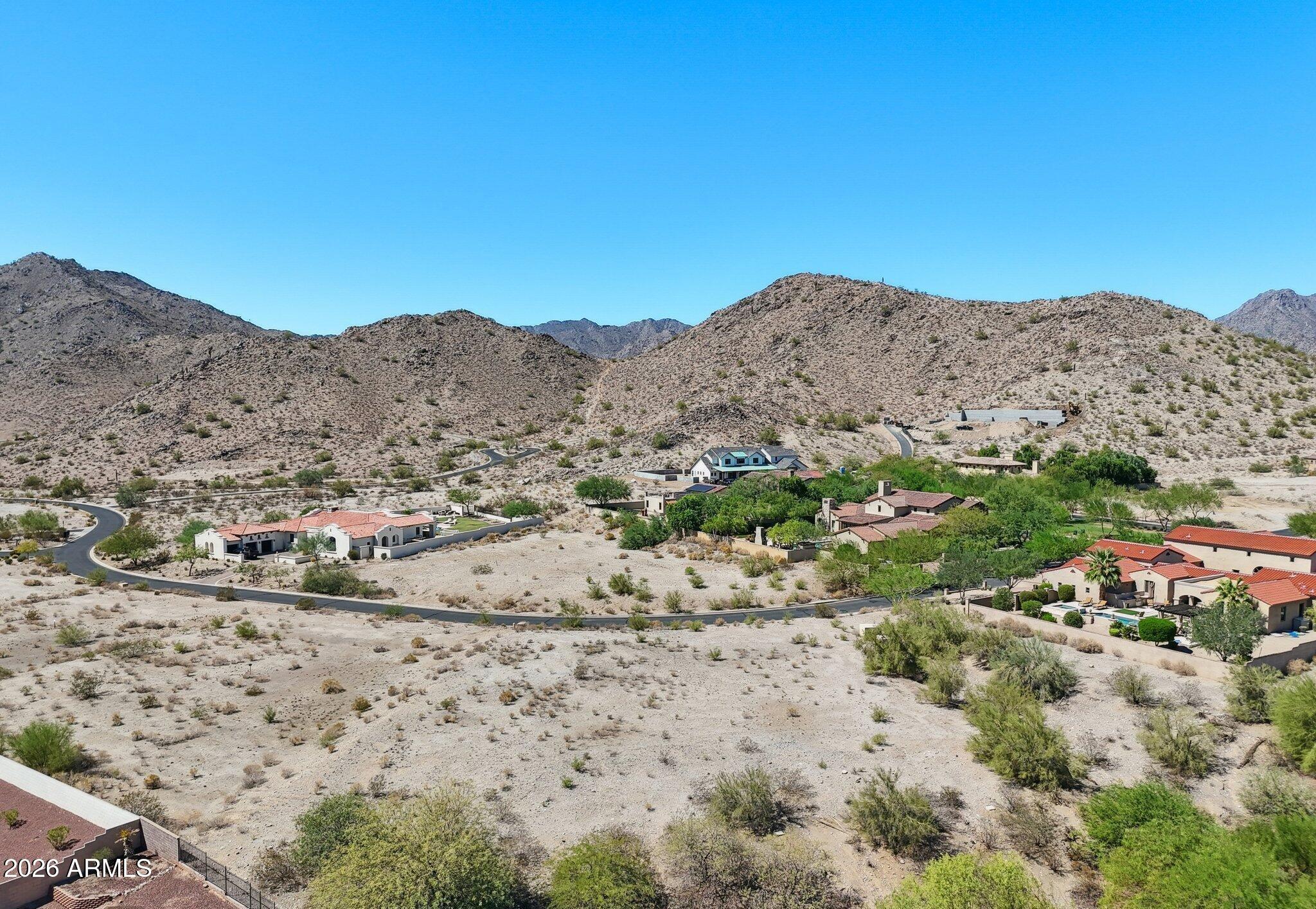Exceptional custom homesite opportunity located in the prestigious Mountain Coves enclave of the Heritage District within the master-planned Verrado community. This premium 0.63-acre homesite offers breathtaking views of the White Tank Mountains, stunning Arizona sunsets, and an elevated setting ideal for a luxury custom residence. The lot provides a rare combination of privacy and convenience, bordered by open space and adjacent to a retention area that enhances the sense of seclusion.