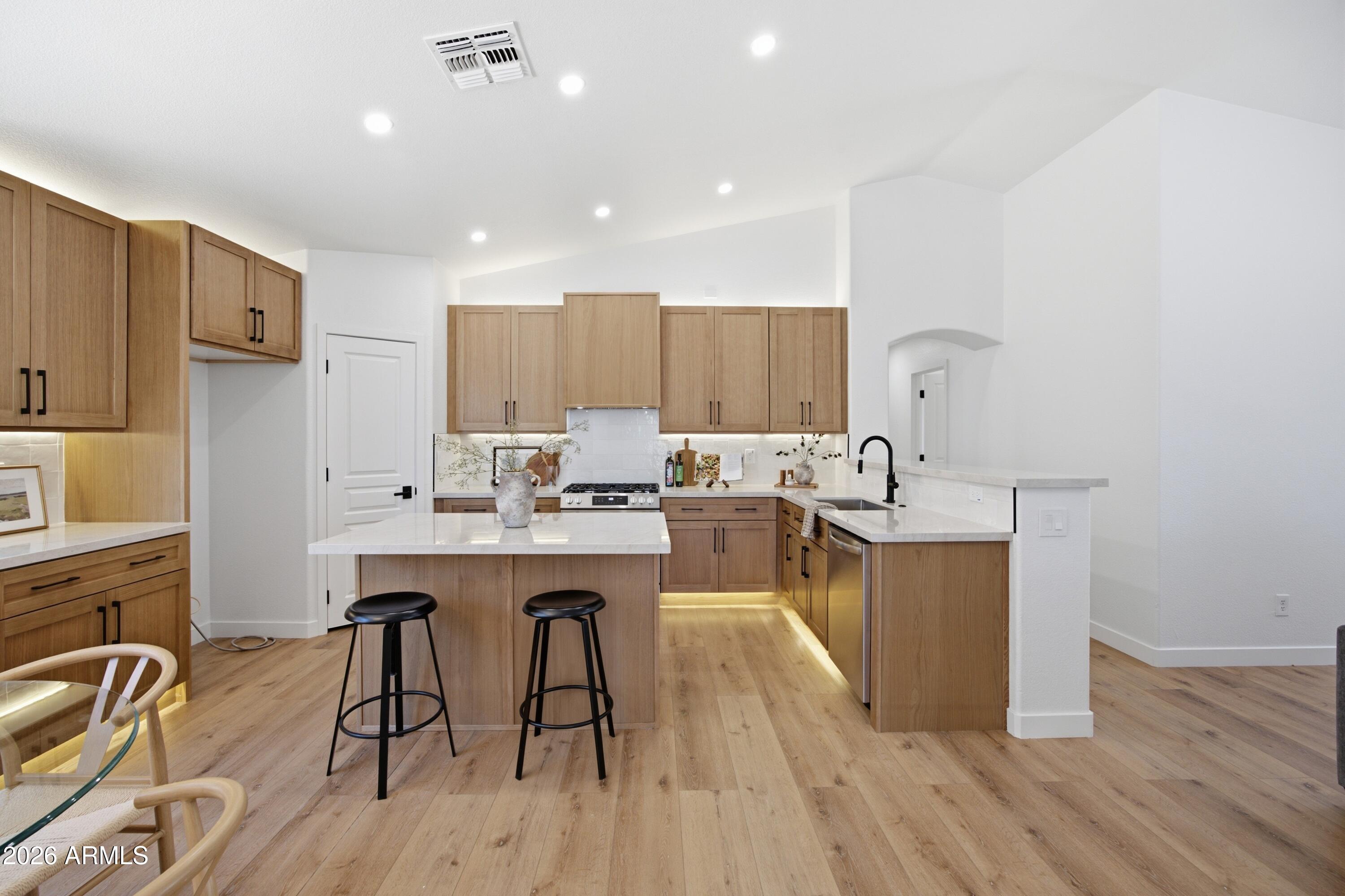 This beautifully remodeled home offers an open-concept floor plan with soaring vaulted ceilings, abundant natural light, designer finishes, and thoughtful upgrades throughout. The renovation showcases white oak shaker cabinetry, neutral quartz countertops, sleek matte black fixtures, new recessed lighting, and neutral wood-look flooring that creates a bright, cohesive living space.

The stunning kitchen is both functional and stylish, featuring Delta plumbing fixtures, ample cabinetry, generous counter space, and a clean, contemporary design that flows seamlessly into the spacious living and dining areas, making it ideal for everyday living and entertaining.

Major system improvements provide added peace of mind, including a brand-new HVAC system and water heater. The spa-inspired bathrooms have been thoughtfully designed with designer tile, extended shower niches with integrated backlit lighting, custom vanities, and elegant backlit mirrors, creating a luxurious retreat.

Step outside to a low-maintenance backyard designed for year-round enjoyment, complete with new turf, pavers, and decorative gravel, offering the perfect setting for relaxing, entertaining, or enjoying Arizona's beautiful weather.

Blending timeless design, quality craftsmanship, modern functionality, and extensive mechanical upgrades, this move-in ready home is truly turnkey and ready to enjoy.