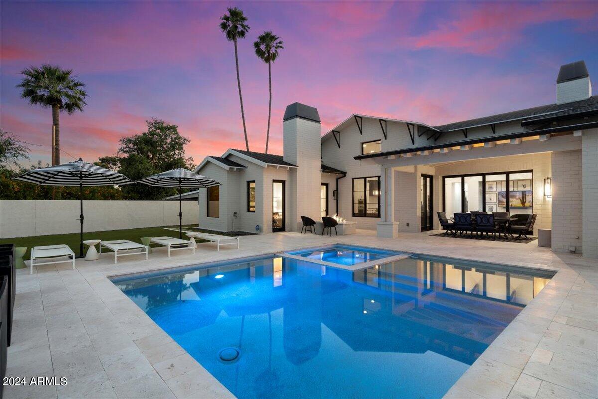 Nestled in the prestigious Arcadia neighborhood of Phoenix, this custom home offers luxury living at its finest. Showcasing a spacious open floor plan, high-end finishes, and modern amenities throughout, this home is quintessential for both entertaining and everyday living. The gourmet kitchen features stainless steel appliances, quartz countertops, and a large island with bar seating. The living room is light and bright with a cozy fireplace and beautiful European Oak hardwood floors. The master suite is a true retreat with a spa-like bathroom and a walk-in closet. The finished basement includes a fitness room, large family room, full bar and an additional bedroom and bathroom. The entire home is handcrafted by Aspect Design Studio and 21 Interiors. Outside, you'll find a beautifully landscaped backyard with a covered patio, sparkling pool and spa, and lush greenery(artificial turf for low maintenance) - perfect for enjoying the Arizona sunshine and views of Camelback Mountain. Plus, the home is conveniently located near top-rated schools, fine dining, shopping, and more.