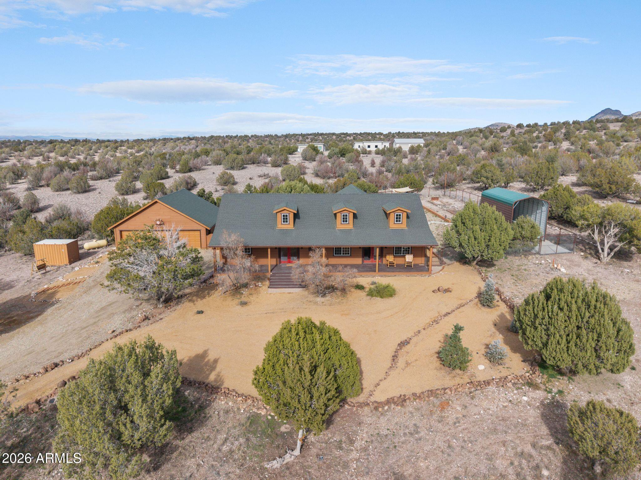 Custom-built 2 bed, 2.5 bath home in desirable Crossroads Ranch with stunning views of Granite Mountain! Offering 2,632 sq.ft. on 10.08 private acres. Thoughtfully designed with quality craftsmanship, this home features a dedicated office space and a spacious great room ideal for comfortable entertaining. The cozy primary bedroom provides a relaxing retreat. Outdoor living is enhanced by a patio with firepit which is perfect for enjoying peaceful evenings and expansive views. Complete with a 3-car garage, this property offers refined country living with privacy, space, and functionality.