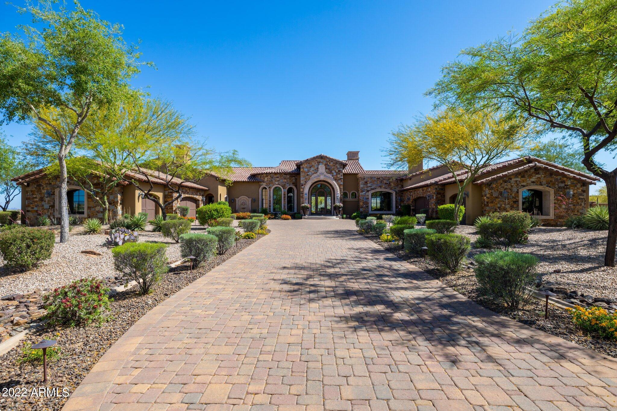 Stunning views await you upon entering this luxurious home located in the exclusive gated Troon community of Cantabrica Estates in North Scottsdale. Situated on 2.54 acres, you will find privacy & tranquility in all the outdoor living spaces while enjoying views of Tom's Thumb to the south, Four Peaks to the east, & Troon Mtn to the west. With over 9000 sqft of indoor living space, the open floor plan seamlessly combines indoor & outdoor spaces making the home perfect for your family needs as well as providing exceptional space for entertaining. Main home has 6 garage spaces, 4 ensuite bedrooms, 3 gas fireplaces, huge family & living rooms with automatic sliding doors to bring the outside in, formal & informal dining spaces, & an executive office with built-in desk, bookshelves & cabinets. The gourmet kitchen has a Wolf 8-burner hooded gas stove & cook top, a commercial sized Sub-Zero fridge & freezer, dual dishwashers, a large island with farm sink & ample prep space, plus a huge walk-in pantry. In addition, the main home has a 100 bottle wine room with brick-lined ceiling, separate wine fridge, tasting counter, plus a media room with comfortable leather recliners for 8 people. The new owners will be spoiled in the main bedroom which includes separate his & hers bathrooms and walk-in closets, soothing spa tub, huge shower, sitting area, and private outdoor space. Your guests will be pleased with the 763 sqft guest house which includes a bedroom plus bath, kitchenette with microwave, dishwasher, & mini-fridge, sitting area, fireplace, separate laundry, and its own private patio. To round out the indoor spaces, there are two separate 3-car extended length garages, each with epoxy floors and no steps to the main living areas, and ceilings high enough for a car lift for storage of additional vehicles. For the technology minded buyer, the whole home has 'Smart Technology' by Control 4 which allows for control or HVAC, lighting, audio, and video from an app on your smart phone. The huge back yard provides tremendous privacy and beautiful mountain views with multiple outdoor covered sitting areas, built-in grill & fridge, another gas fireplace, outdoor TV, and beautiful landscaping. The sparkling pool and spa are heated so they can be enjoyed year round. An AguaLink control panel inside the home allows for remote control of the pool, spa, and water features. The low maintenance turf will stay green and beautiful all year long. The peace and tranquility of the Sonoran Desert surround this home with stunning mountain views in every direction, yet the City of Scottsdale is only a few minutes away making this the perfect location. Mastro's Steakhouse and AJ's Fine Foods are a short 10 minute drive and if you prefer Carefree, it is only 12 miles from the home. You could hike the Tom's Thumb Trail and be in Carefree for lunch. Perfect home and location for the discriminating buyer.