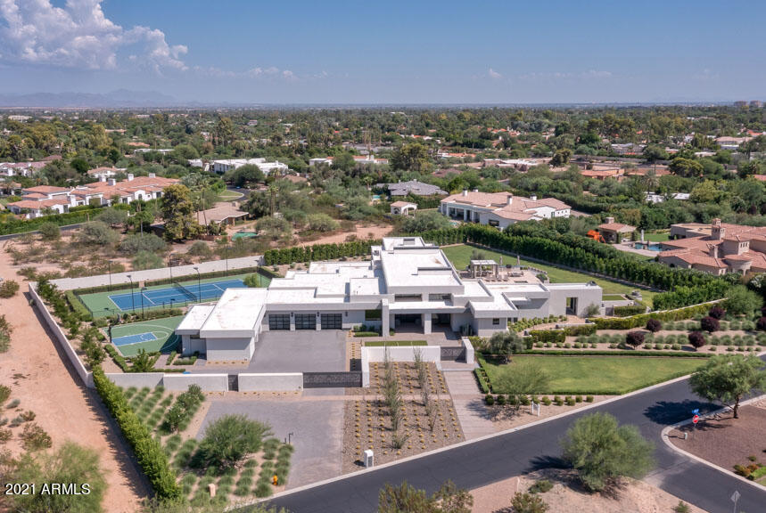 Sitting on 2 ACRES with JAW-DROPPING views of CAMELBACK MOUNTAIN this stunning contemporary has it all! 90 degree retractable glass walls in the great room open to a 60 FT X 24 FT infinity edge LAP POOL, expansive patios, and huge grass backyard. Outdoor amenities include a lighted tennis court, separate half basketball court, fireplace, walk-in shower + pool cabana.