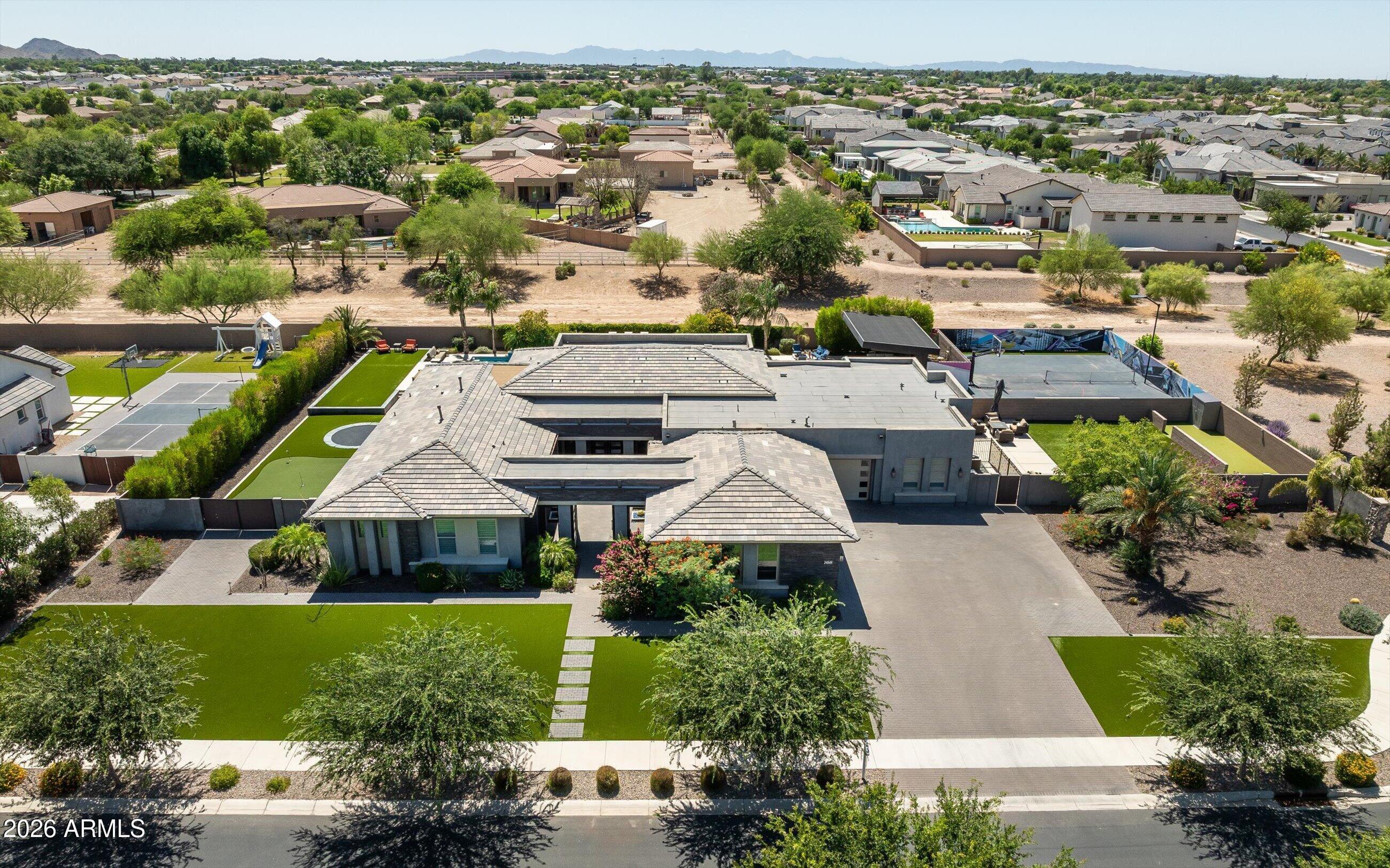 Experience elevated desert living in this extraordinary contemporary estate located within the prestigious gated enclave of Whitewing at Whisper Ranch. Designed for seamless indoor-outdoor living and exceptional entertaining, this one-of-a-kind residence showcases a spectacular resort-inspired backyard paired with refined luxury interiors.

The outdoor environment rivals a private five-star resort, centered around a dramatic 70-foot diving pool featuring two sheer descent water features, seven ColorVision bubblers, four oversized Baja shelves, spa, beadcrete plaster finish, gas heater, heat pump, ozone/UV purification system, and in-floor cleaning. A custom 14' x 28' steel cantilever pergola creates a striking architectural focal point, while five fire bowls add warmth and ambiance throughout the evening.

Designed for both recreation and relaxation, the grounds also include a basketball court, pickleball court, putting green, and in-ground trampoline. Expansive natural stone decking provides multiple entertaining spaces enhanced by integrated landscape lighting and outdoor sound. A lush private turf area adds another layer of resort-style living, offering the perfect setting for relaxing outdoors, enjoying the greenery, or gathering with family and friends for lawn games and casual entertaining.

Inside, the home welcomes you with expansive open-concept living spaces curated for luxurious entertaining. The chef's kitchen is anchored by dual quartz top islands and opens effortlessly to the outdoors through a dramatic sliding wall of glass, creating true Arizona indoor-outdoor living. Additional gathering spaces include a dedicated billiards or media room and private den. The oversized laundry room is thoughtfully designed with extensive storage, cabinets and sink.

The luxurious primary retreat offers a true spa experience, featuring designer glass tile finishes, granite countertops, soaking tub, separate vanity area, and two oversized custom walk-in closets. Each secondary bedroom includes its own en-suite bath and walk-in closet, while the detached casita provides ideal accommodations with a private living room, bedroom, full bath, and walk-in closet.

Recently completed upgrades including new white oak wide plank hardwood flooring, fresh interior paint and beautifully updated bathrooms with limestone bathroom floors, further elevating the home's refined contemporary aesthetic. Additional highlights include automated window shades throughout the main living spaces, designer lighting, and exceptional custom finishes throughout.

Residents of Whitewing at Whisper Ranch enjoy access to premier community amenities including a clubhouse, fireplace lounge, bocce court, playground, dog park, and scenic walking and hiking trails.