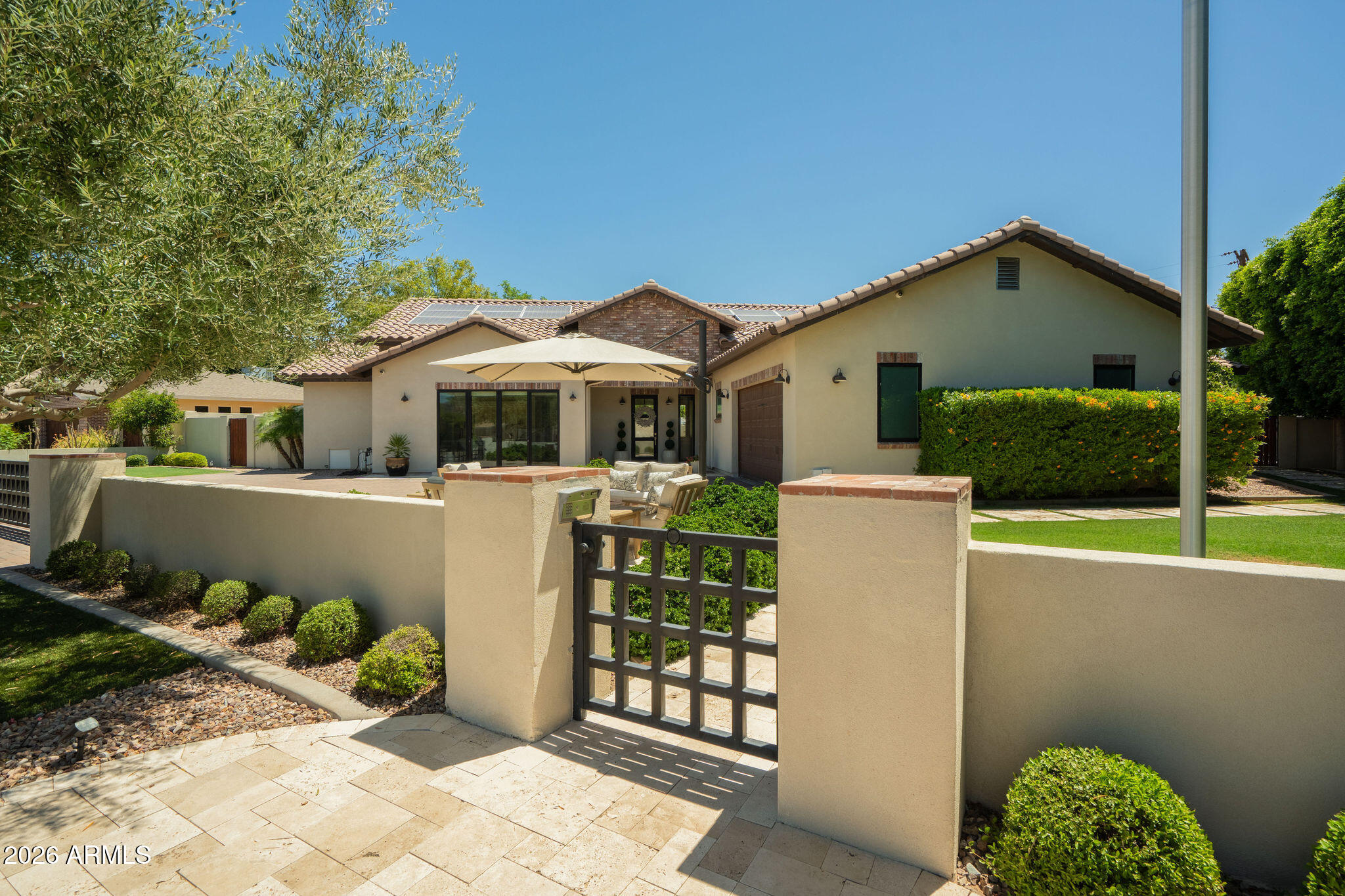 Welcome to this stunning custom ranch in the heart of Arcadia Proper, within the highly sought-after Hopi School District. A gated entry with firepit and views of Camelback Mountain sets the tone for the privacy and sophistication that awaits. The great room features wall-to-wall glass doors and windows that seamlessly connect to the resort-style backyard, complete with a covered patio, pool with expanded deck, Ramada with built-in BBQ, artificial turf, sport court, and a second firepit. The chef's kitchen is anchored by an oversized island and outfitted with premium Wolf and Sub-Zero appliances. The split floor plan offers privacy for all, with a versatile flex space ideal for a home office or playroom. The primary suite is a true sanctuary, featuring a steam shower, soaking tub, and beautiful natural light. Every bedroom enjoys views of the stunning lot and backyard. Smart living meets sustainable comfort with a Crestron smart home system including indoor, outdoor and garage surround sound, owned solar panels, water softener, and an air-conditioned garage. This is Arcadia living at its finest.