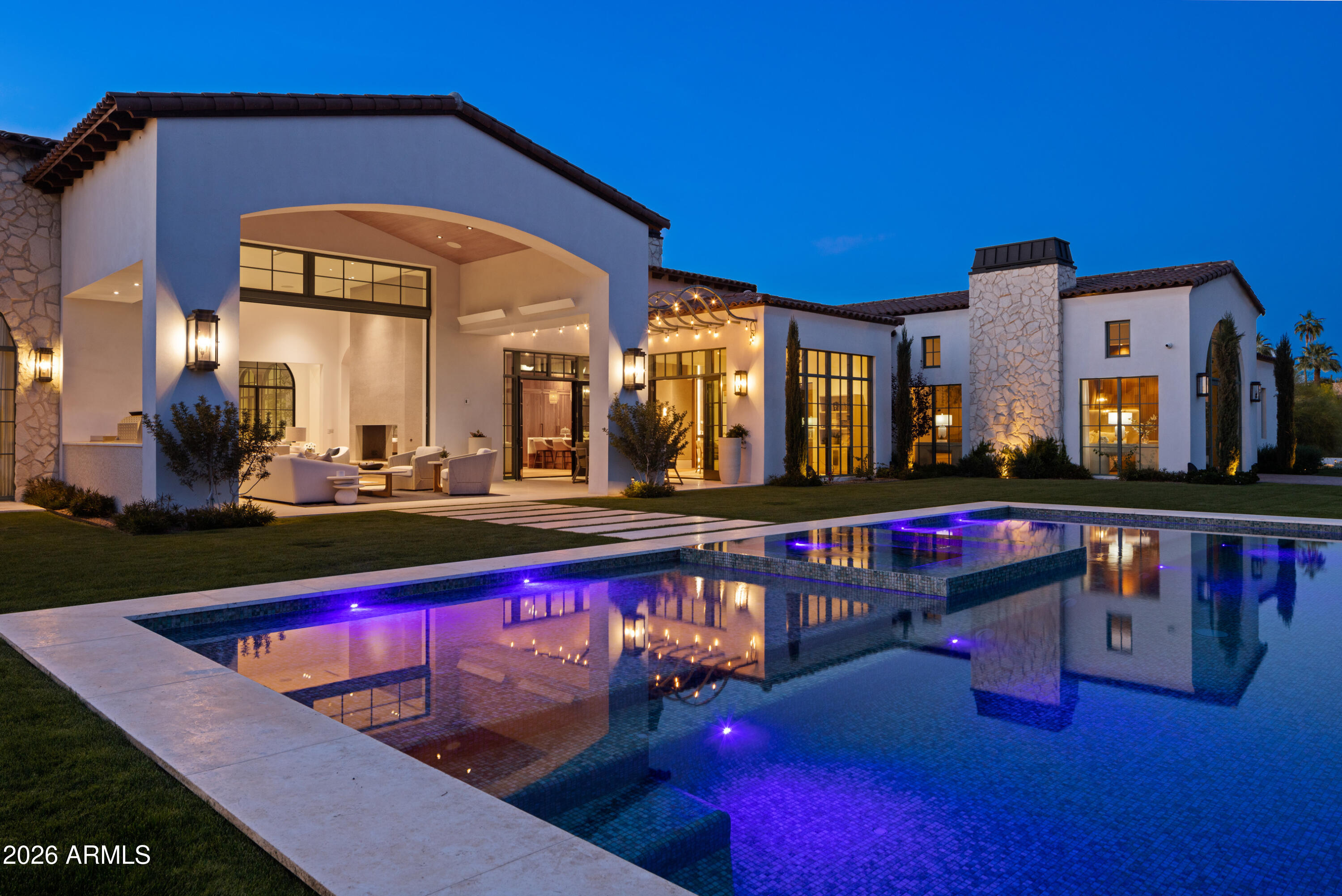 Newly built in 2025, this exceptional Paradise Valley residence blends a refined transitional style -- melding the warmth of Santa Barbara architecture with modern design plus top-tier finishes -- and captures dramatic views of Camelback Mtn, including the Praying Monk and Head of Camelback. The great room features soaring 18-foot ceilings and a dramatic Italian tile fireplace, opening to outdoor living with a fully tiled negative-edge pool, manicured lawn, and a premium Hestan grill and pizza oven. The chef's kitchen is anchored by BlueStar appliances, a spacious back kitchen w/ additional appliances + walnut Artitalia cabinetry with special organizers. A luxurious primary wing offers a unique glass sauna with contiguous glass steam shower, dual towel warming drawers, 2 large closets... plus a long glass shelved hallway to showcase handbags. Crestron automation, Palecek lighting and quartzite cristallo counters Enhance the sophisticated feel of the home. Additional highlights include a large brick ceiling wine room, a theater, office, mudroom cabinetry and dog wash station.