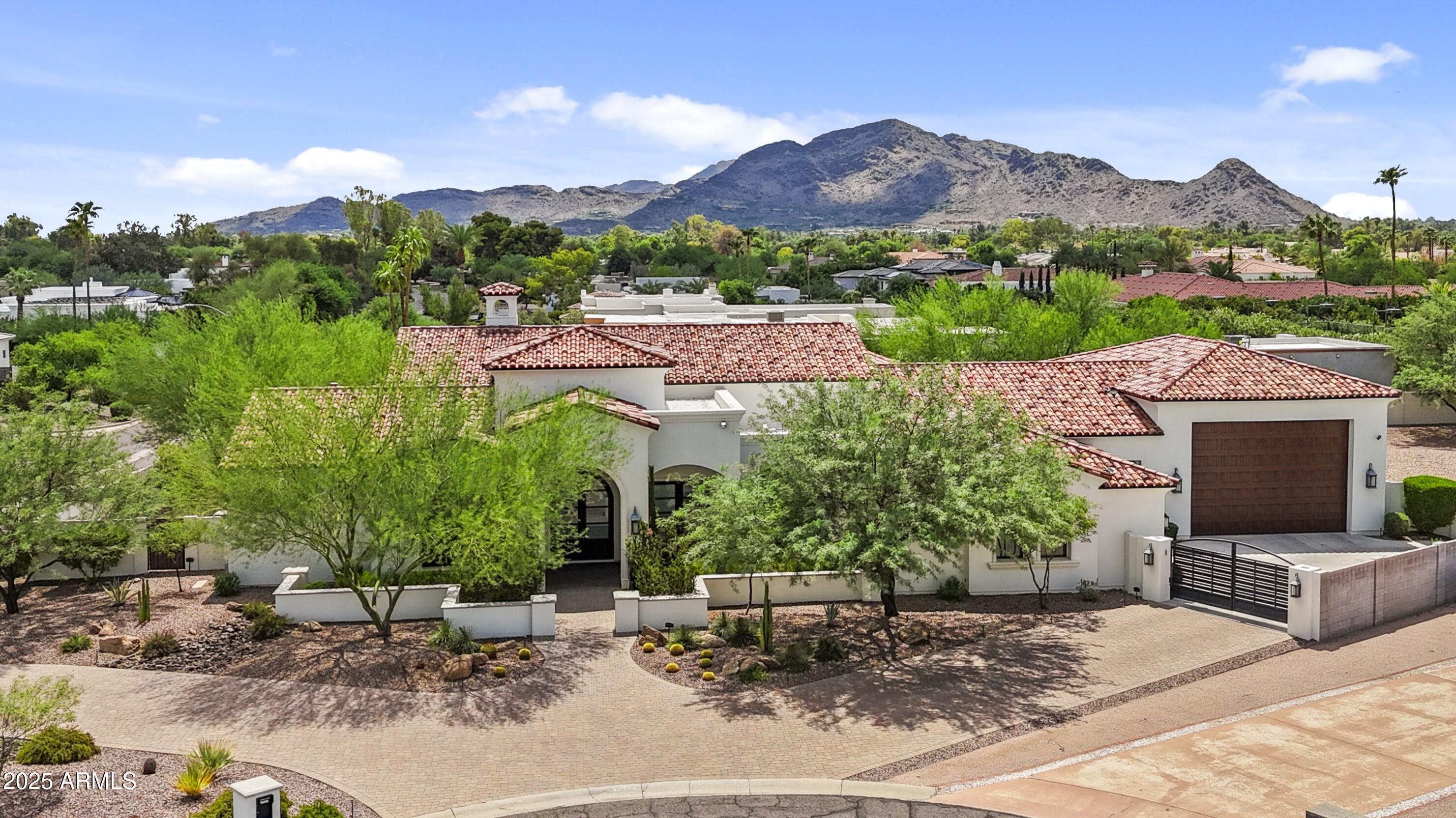 Gorgeous Paradise Valley Estate! Modern single story soft contemporary with 4 bedrooms/4.5 bathrooms, split 6 car oversized garage with huge RV garage! This fabulous estate has a great room open floorplan with soaring high ceilings, wood beams, a grand gas fireplace, & an enormous retractable wall of glass doors to fully elevate the inside/outside living experience! Gourmet Chef's Kitchen has Custom cabinetry, twin Sub Zero refrigerator & freezer, 60'' Wolf Gas Range and twin dishwashers! Expansive primary suite has a large spa-like walk through shower w/dual glass entrances, HIS/HER vanities, enormous walk-in closets and a relaxing soaking tub & gas fireplace! All secondary bedrooms have bathrooms en suite in addition to a sizeable game room! Huge backyard with resort style pool and spa. Resort style water/fire features in addition to a large gas conversation/fire pit! So much to see in this exquisite PV home!!