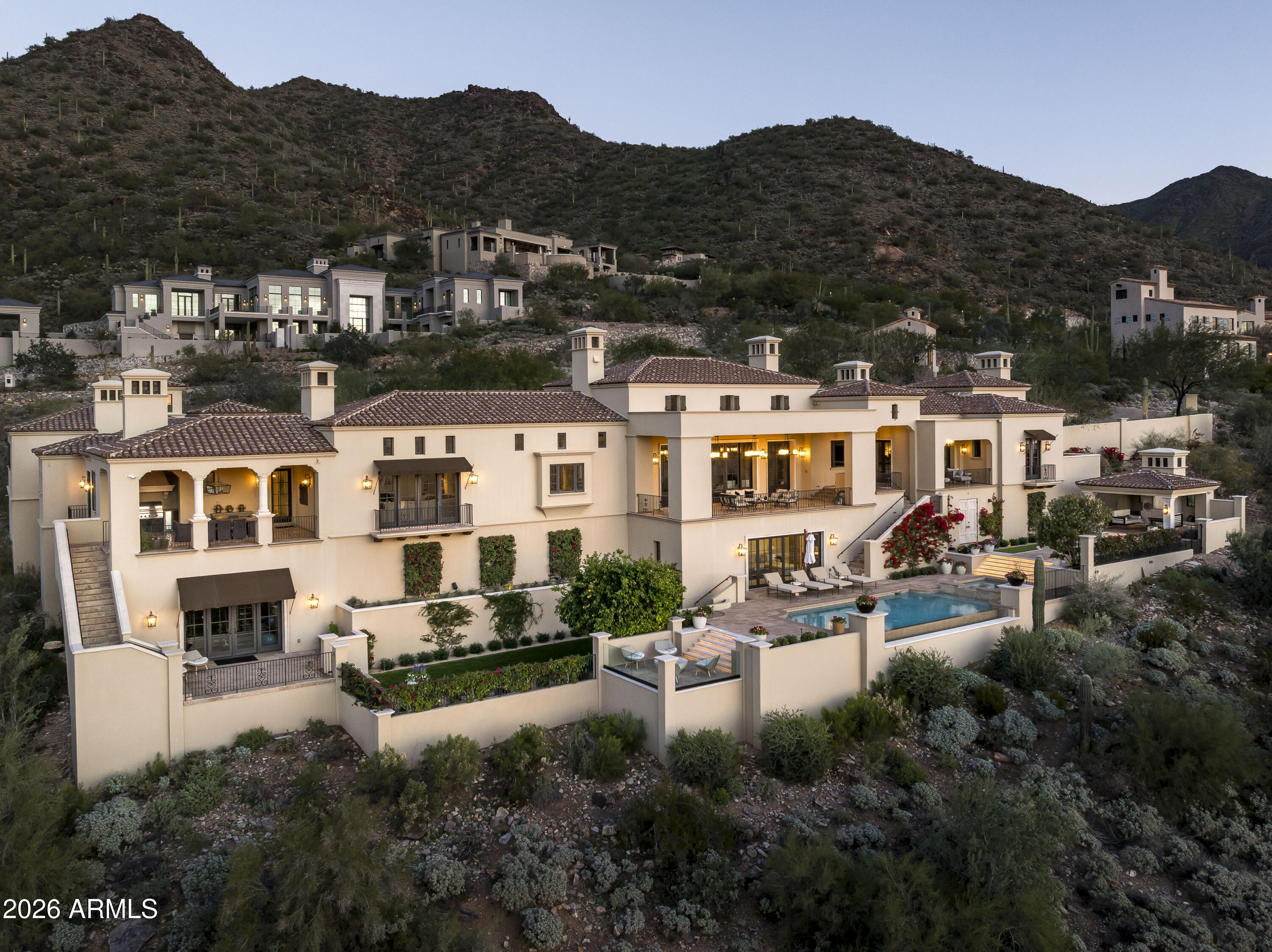 Renowned for its exceptional architecture, breathtaking views, and unparalleled lifestyle, the prestigious Silverleaf community sets a standard of excellence—one this remarkable residence fully embodies. The home commands one of the most extraordinary, completely unobstructed views in Silverleaf, delivering dramatic vistas along the expanse of the home.
Approached by a graceful, tree-lined drive, the 8,303-square-foot Salcito Custom Home is framed by lush, mature, and colorful landscaping that perfectly complements its exquisite architectural design. Upon entry, the eye is immediately drawn to the expansive views and abundant natural light, creating a striking sense of arrival.
Thoughtfully designed for both comfort and functionality, the main level hosts the primary living spaces, including the living and dining rooms, family room and kitchen, office, theater, master sitting room, and three bedrooms. The lower level is reserved for a spacious guest suite and a versatile pool cabana. Pool cabana can also be a 5th ensuite bedroom.
Throughout the home, sophisticated finishes reflect a timeless, classic elegance equally suited for refined entertaining or relaxed everyday living. Outdoor living spaces are beautifully enhanced by curated landscaping and multiple intimate venues, ideal for enjoying vivid sunsets, brilliant city lights, and the tranquility of surrounding mountains.
This exceptional estate offers the ultimate in luxury, and resort-style living, evident in the photos and video, truly your own private sanctuary.