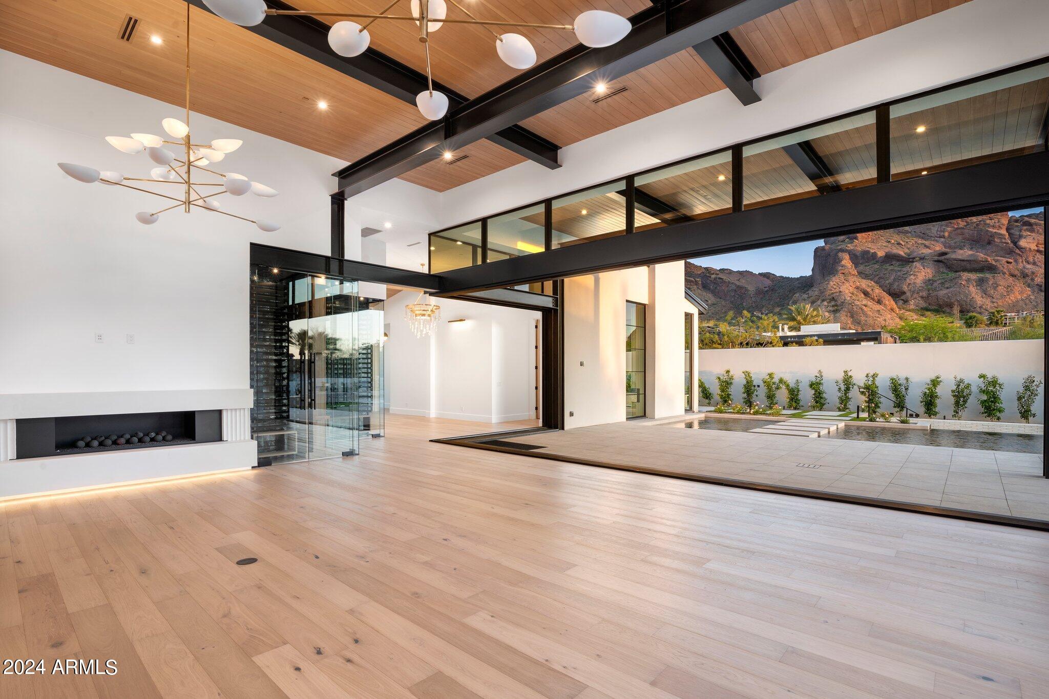 Location and architectural design rarely combine to result in an offering as rare as 51st Place, a 2024 ground up new build, breathtaking views of iconic Camelback Mountain seen throughout property, the interiors will astonish from the hand-selected lighting, concrete fluted fireplaces, millwork, wall treatments is nothing but the best. Chefs kichen with dual islands, loaded with appliances throughout home, recharge in the resort inspired primary suite with a glass wall to patio, large dual walk in closets both triple hung and her closet with a waterfall island, steam shower. 16' ceilings in family room which continue through to the covered patio framing Camelback mountain and a glass tiled negative edge heated pool with built in bar stools, the pool incorporates two sunshelfs, the architecturaly appointed steel beams cantilever at patios complimenting the home, escape to the private guest house in the rear of property consisting of a full kitchen, the estate home is gated and walled in for privacy, glass garage doors, 4 car oversized garage has been air conditioned and capable of staking cars with built in cabinets and work bench, 1158 bottle climate controlled wine wall with natural walnut accents the front entry, a large butlers kitchen with coffee bar, entertain at its best in the impressive game room which consists of a sunken theater room and a large built in bar, a large interior courtyard with fireplace is located off the main living area and you'll find large oversized glass doors and windows throughout, 90 degree pocket doors as you enter the home to show off the impressive backyard with artifical turf and a putting green, a view deck to catch the sunset views and enjoy the built in bbq/bar area and the 9' long steel firepit all on view deck, the view deck is accessed by a steel and glass staircase which is a true work of art, main patio consists of a second built in bbq/bar area easily accessible to kitchen, a firepit poolside, no expense was overlooked on this home, grounds are landscaped at its best, come see what 24 years of striving for perfection has created by J.M. Wall Development, nothing of its kind and quality on the market, a true luxury home at its best!