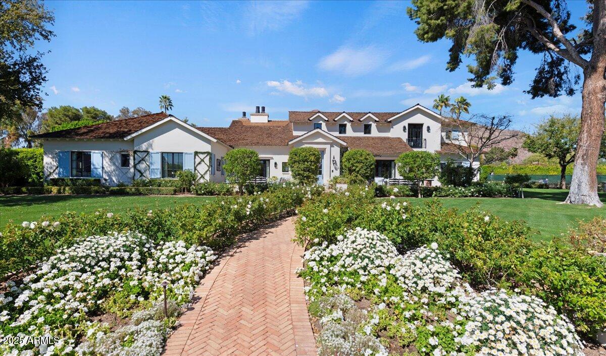This exquisite estate is one most can only dream of owning. The timeless design is rich with character and offers a beautiful mix of traditional and fresh elements. The grandeur couples with comfort creating spaces that are as easy to envision quaint family celebrations as to imagine large scale social events. The top-of-the-line chef's kitchen is equipped with a huge island, farmhouse sink, Wolf and Subzero appliances and a butler's pantry with more room for storage and prep. The impressive formal and informal living spaces both have fireplaces, while retractable doors stretch across the entire great room seamlessly blending indoor and outdoor living, and the formal and informal dining rooms offer both elegance and warmth. In addition, there's a full restaurant style bar with temperature controlled wine storage ensuring you'll be stocked and ready for entertaining at a moment's notice. All the bedrooms are beautiful, and the primary suite is magnificent featuring a spacious seating area in front of a lovely fireplace, a spa like bath, its own washer and dryer in the huge closet, and mountain views from the veranda that are simply breathtaking. The private office will make working from home the preference and you can grab a workout before in the home gym. The meticulous grounds rival the beauty of the home featuring multiple patios, meandering walkways, a gorgeous pool, spa, built-in barbecue and a pickle ball court. Sitting on arguably the best stretch of Exeter Blvd with glorious mountain views, and surrounded by multi-million-dollar estates, this impeccable residence offers an unparalleled lifestyle and unique pride of ownership!