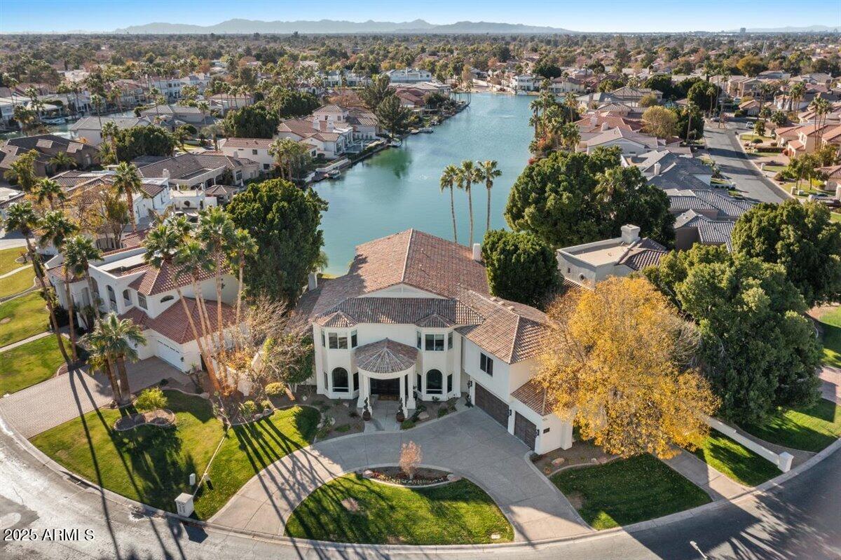 New Price on this beauty that just won ''Best of Tour'' on the Gilbert Luxury Tour! Discover the epitome of refined living in this breathtaking waterfront estate! Nestled in prestigious West Lake Estates, this Interior Designer's personal residence offers a perfect blend of sophistication, comfort & unparalleled design aesthetic. This home is a statement of elegance, offering one of the finest living experiences in the valley. Take in all of nature's splendor w/our beautiful AZ sunsets in this impeccably designed, sprawling estate, w/a unique 1/4 mile water view. This estate boasts 4 expansive bedrooms, 5 beautifully appointed bathrooms, a chef inspired kitchen, a beautiful & functional masterpiece featuring top-tier appliances by Thermador, custom high-end cabinetry, double islands, and the heart of all the home's activities; all while capturing the amazing
lake views! You will find multiple, expansive patios offering several places to dine, relax and enjoy the sparkling negative edge pool & spa, ideal for relaxing and enjoying the lifestyle that only Val Vista Lakes provides. Every detail in this estate has been
meticulously designed including designer wall features, exquisite
lighting, and sophisticated, artisanal finishes that exude timeless
elegance with comfortable appeal.Car lovers rejoice, this home
offers a rare, oversized 4 car garage so bring your toys! Val Vista
Lakes, a pinnacle lifestyle destination in the valley of the sun
offers lakes, tennis, pickleball, sport courts, walking paths,
swimming pools and a full clubhouse brimming with amenities,
clubs and social opportunities. Just steps away the community
provides churches, schools and a vibrant dining and shopping
experience. Don't miss this once in a lifetime opportunity to own
one of the most beautiful homes in the valley and experience the lifestyle you deserve!