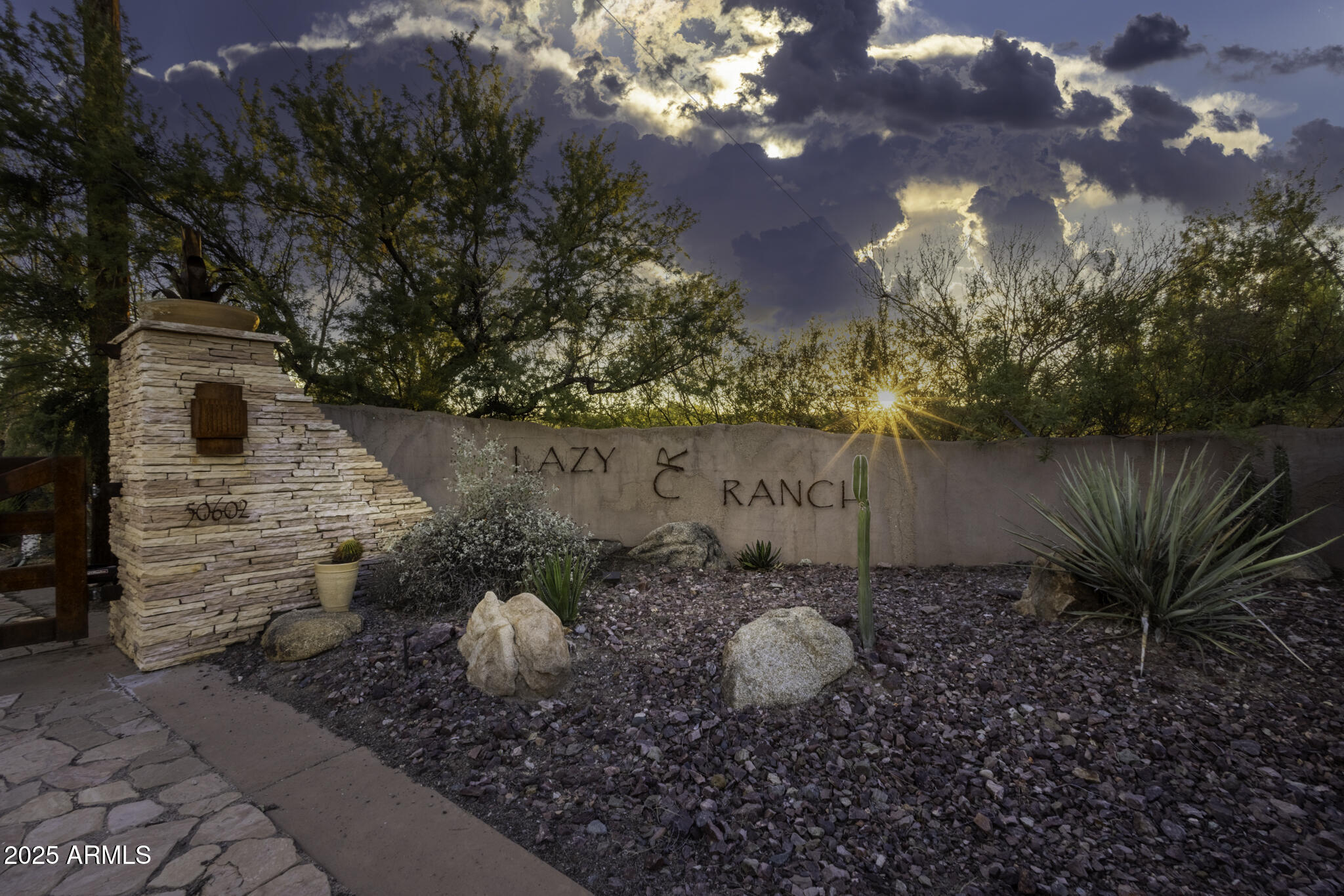 Discover the legacy of the Lazy RC Ranch, an expansive 70+ contiguous acre property bordering the Hassayampa River with four private entrances directly accessible from Highway 60. This estate features a meticulously upgraded residence offering three bedrooms and two and a half bathrooms, library & den complemented by a detached three-car garage. Interior highlights include cherry wood cabinetry, Indian Piranha Granite countertops, an Ashfork stone fireplace, and a combination of wood, tile, and crisp white carpet flooring. Elaborate outdoor entertaining gallery overlooks the Hassayampa River, complete with intimate walking paths down to the riverbed. Extensive landscaping and water features surround the home and appear throughout the grounds. 
The property also boasts a 5,966 square ft climate-controlled workshop and event center offering his and hers offices as well as a kitchen and full bath; adjacent to a quarter-acre pond stocked with Bass, Blue Gill and Catfish finished with waterfalls and hand-laid flagstone paths. 

The centerpiece of the tranquil property may be the Pecan Orchard and the many varieties of fruit trees including apples, peaches, lemons, limes, pomegranates, and tangelos, harboring an abundance of wildlife. 

A historic element, the Rock House or "Miners Ramada," originally constructed in 1920, serves as an inviting venue for outdoor events, quiet evening dinners and relaxation. Spanning nearly one mile, the property offers numerous trails and walking paths devotedly created with hand placed flagstone, river rock, and timbers. 

Guests may enjoy the river walk overlooking the riparian nature conservancy, meditation points, and hilltop lookout areas amidst diverse elevations and mature arboreal landscapes.

On the main property there are currently 10 Full RV Hookups (30 & 50amp) strategically placed: two on the hilltop above the pond with extraordinary views and four nestled above the river walk overlooking the treetops of the Hassayampa River. 

The northern portion of the property offers approximately 40 acres and once was irrigated pasture. Now it has returned to its natural state and includes incredibly large eucalyptus trees and native Arizona fauna. This portion can viewed with an off-road vehicle or explored on foot. The entire property is completely fenced. 

The southern section consists of more than six acres of secluded land behind a privacy wall, with its own entrance from Highway 60. Previously a 25 space mobile home park, it now retains three septic tanks and 4 full RV hookups with water and electricity. Zoned M-5 (Multi-Family) and C-2, this segment offers considerable potential for investment and income generation.
 
Additionally, on the opposite side of Hwy 60 one parcel being offered includes an income producing billboard. 

Originally part of the historic Brill Ranch, established in 1866, when 700 head of cattle were driven from California to the pristine banks of the Hassayampa in Wickenburg, Arizona.  The current ranch borders the Nature Conservancy and features direct highway access. The unparalleled privacy, prime location, and investment opportunity offered here is unprecedented in Wickenburg.

Transitioning from its origins as a cattle ranch to a guest ranch, and now a private retreat, the Lazy RC Ranch invites qualified parties to experience its rich history and explore the endless possibilities.