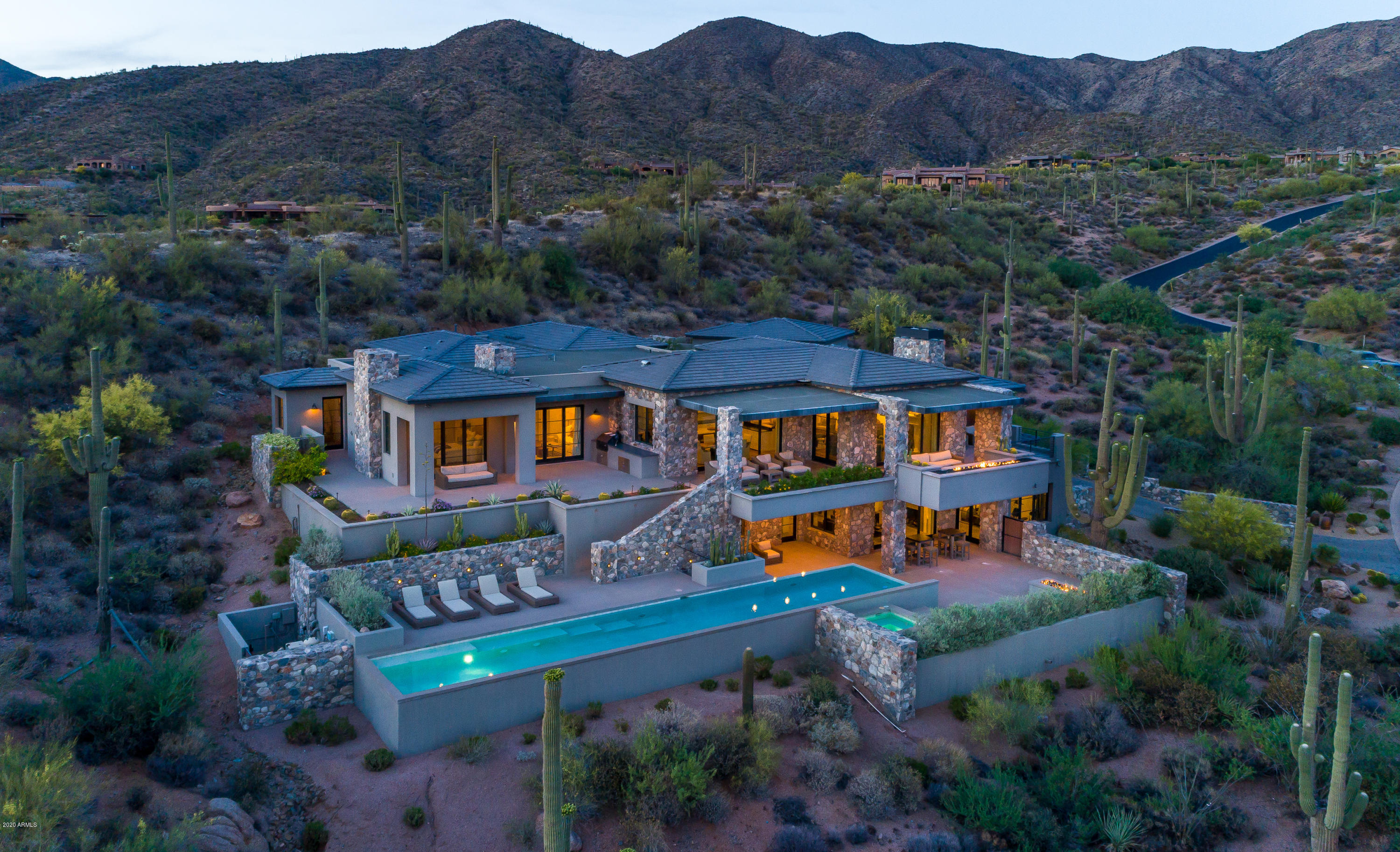 Coastal California meets the High Sonoran Desert with a one-of-a-kind contemporary estate on 2.2 acres offering a very serene and private setting.  Located high above the valley of the sun in the exclusive community of Desert Mountain in North Scottsdale, Arizona.  This home has all of the views Desert Mountain is known for from the McDowell Mountains, Pinnacle Peak, sparkling city lights, distant emerald green golf course views and beautiful sunsets.  The interior is light and bright with an abundance of natural light, telescoping doors and an open functional great room floor plan on the main level with NO STEPS.  Offering three suites  on the main level (one of which is the master bedroom with sitting area, study and expansive closet), kitchen, dining room and great room area. The lower level offers a game room with large wet bar, a pre-wired ready to be finished media room and three suites, one of which is used as a fitness room. There is an elevator as well to this level. Also NO STEPS on the lower level  The lower level living space has its own patio complete with fire feature, in ceiling electric heaters and direct access to the pool and spa as well to the main level.  Outdoors enjoy a 60 ft lap pool, spa, two fire features and plenty of outdoor living space. List price includes all electronics/tv's. Equity Golf Membership available via separate bill of sale as well as most furniture/furnishings.  See the Document tab for a description of the home electronics.