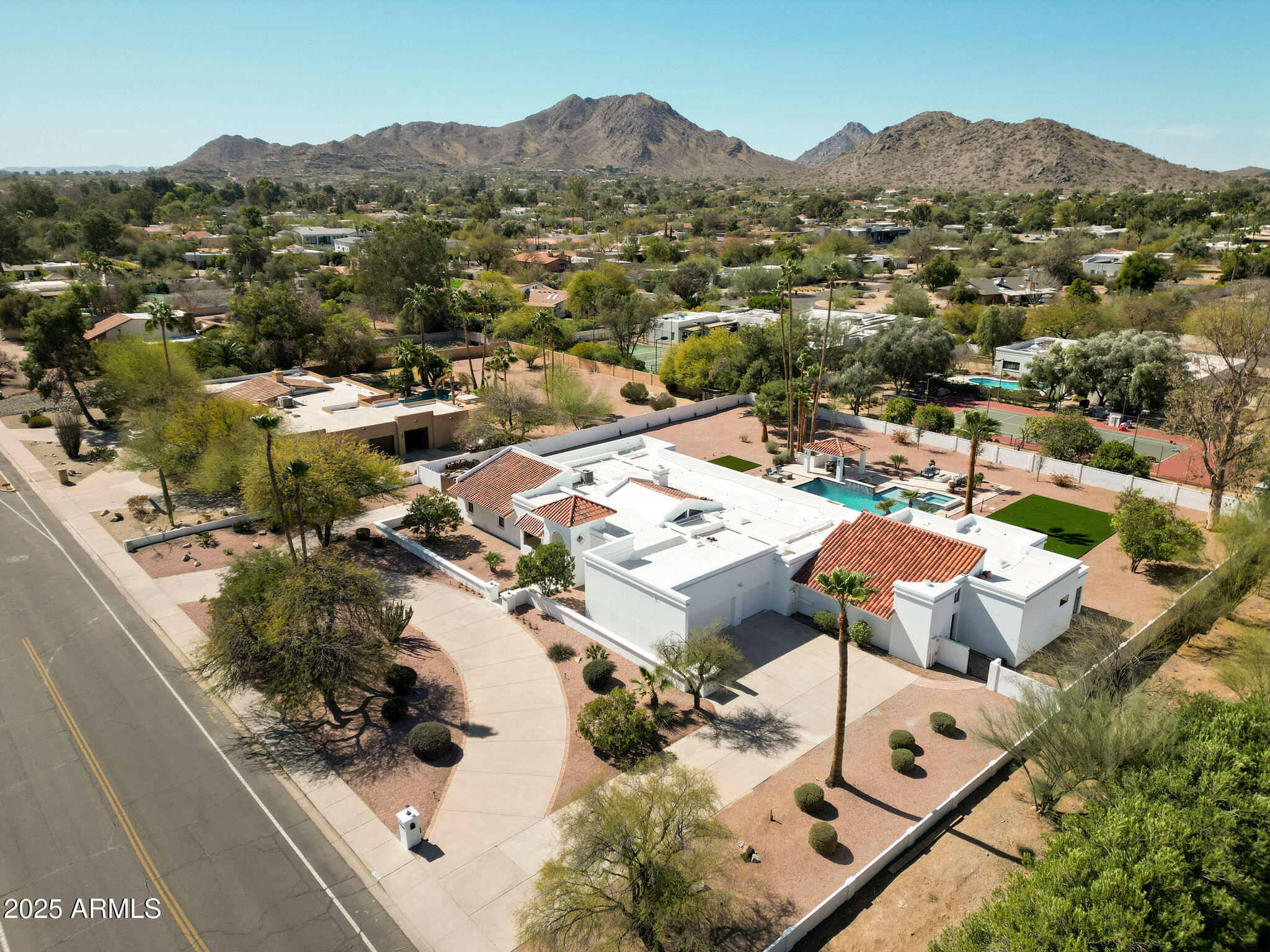 A Masterpiece of Luxury in Paradise Valley! This extraordinary estate has been completely transformed with over $1.5 million in high-end renovations, creating an unparalleled blend of elegance and modern sophistication. Nestled on nearly an acre of prime real estate with no HOA, this property offers endless possibilities, including room for a standalone custom garage or gym, plus a side RV gate for added convenience. Designed for both grand entertaining and serene everyday living, the resort-style backyard is a true showstopper—featuring a newly remodeled heated pool and spa, gas fire pit, ramada, and a brand-new built-in gas barbecue, all surrounded by lush, mature landscaping. There's even ample space to add a pickleball court or other outdoor amenities to suit your lifestyle. Inside, this 5-bedroom, 4.5-bath home is a masterclass in craftsmanship. Vaulted ceilings with exposed beams add warmth to the expansive family room, while the gourmet chef's kitchen is an absolute dream, featuring a Sub-Zero refrigerator, Wolf range, two dishwashers, an oversized quartz breakfast bar, a butler's pantry with a wine fridge, and a coffee station. The primary suite is a sanctuary unto itself, boasting a soaring wood-beamed ceiling, cozy fireplace, and a spa-inspired bathroom with Quartzite slab walls, a body spray shower system, a private toilet and bidet, and dual walk-in closets. The attached full casita offers a private kitchen with quartz countertops, stacked washer/dryer, and separate entry, making it ideal for guests, multigenerational living, or even an upscale home office. For added convenience, the main laundry room is equipped with two stacked washer and dryer sets, ensuring effortless living. A rare opportunity to own a fully upgraded estate in one of Arizona's most sought-after luxury communities. This home is nothing short of spectacular!
