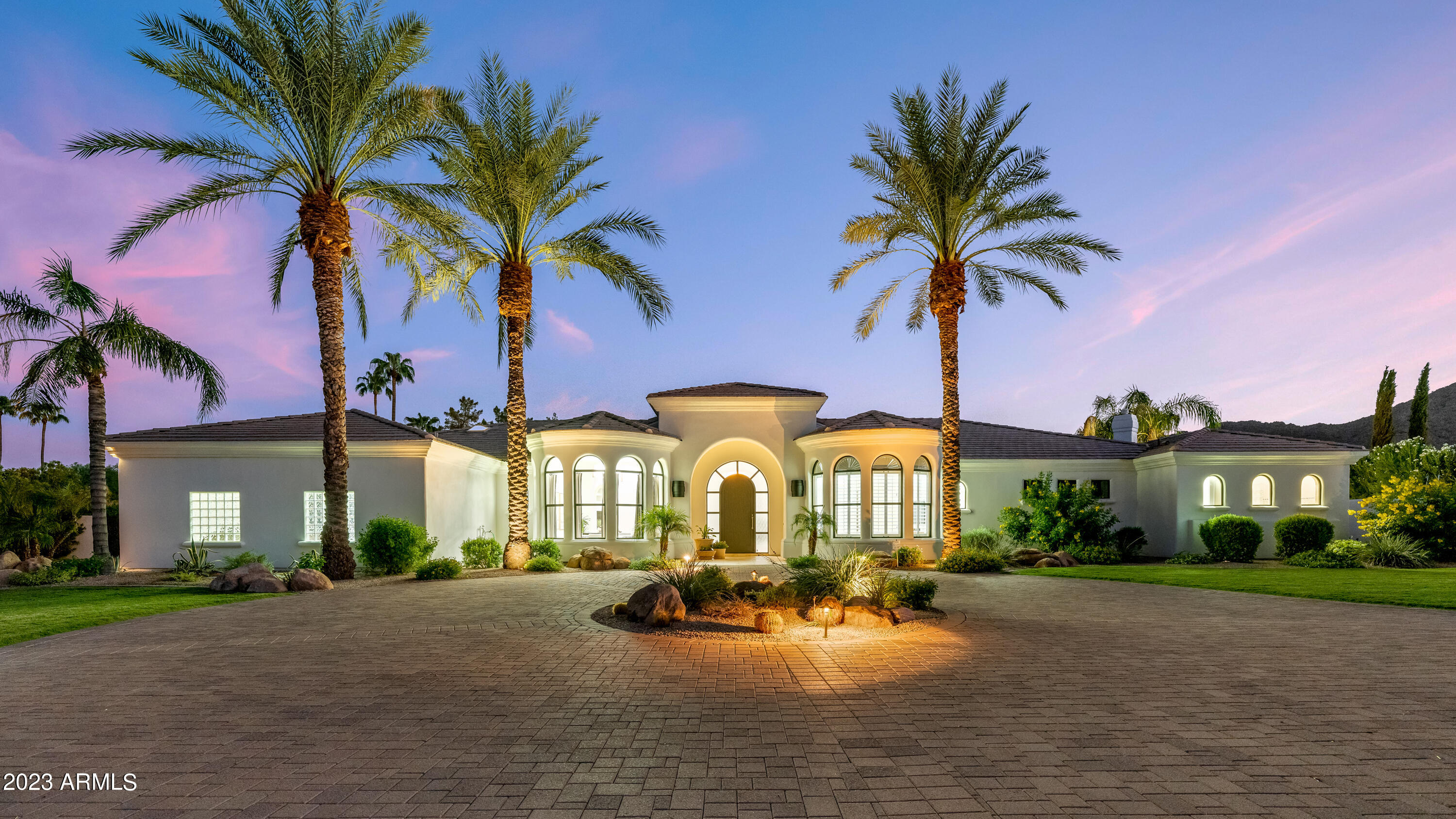 Welcome to this timeless masterpiece, where style meets functionality, nestled in the heart of Paradise Valley. Spanning over 5300 square feet, of luxury living space, this home boasts five bedrooms and four and a half bathrooms and is perfect for accommodating family and guests. 
Upon entering the home, via a large circular driveway, you will be greeted by gorgeous Mummy Mountain views and lush mature desert landscape, providing a graceful introduction to this exceptional estate. 
As you step through the doorway, you will be captivated by the grandeur of this home with soaring ceilings, travertine flooring, and a seamless flow from room to room. The formal living and dinning rooms, set the stage for elegant gatherings. 
The gourmet kitchen features a Viking cooktop, Wolf double... oven and microwave, Sub-Zero side-by-side refrigerator, granite counter-tops and center island, ideal for culinary creativity. Adjacent to the kitchen is a wet bar, complete with sink and ice maker to craft your favorite cocktail.  For the wine enthusiast, there is an impressive, 415 bottle  temperature-controlled wine cellar to keep your wine collection, perfectly preserved.
 Wake up to majestic Camelback Mountain views from the master bedroom.  Grab a drink from the mini fridge and enjoy the two-way fireplace, from a cozy sitting area, or the relaxing jetted, soaker tub.  A second master bedroom is located on the opposite wing and both offer separate access to the outdoor amenities.
The south facing resort style backyard is an entertainer's dream.   The huge covered patio with speakers and misters overlooks the lush tropical landscaping and, lagoon-like, nine foot deep, pebble-tec pool,  which has three cascading rock waterfall features, a slide, grotto and heated spa. You can enjoy some friendly competition of pickleball, basketball, or badminton on the multi-purpose sport court, or refine your short game on your very own putting green with a sand trap and chipping area. The outdoor fireplace and built-in barbecue, complete this oasis, which is all set against the serene backdrop of iconic Camelback Mountain views. 
Luxury, comfort and style converge in this magnificent custom home. Do not miss the rare opportunity to make this one-of-kind residence your own. Schedule your private showing today!