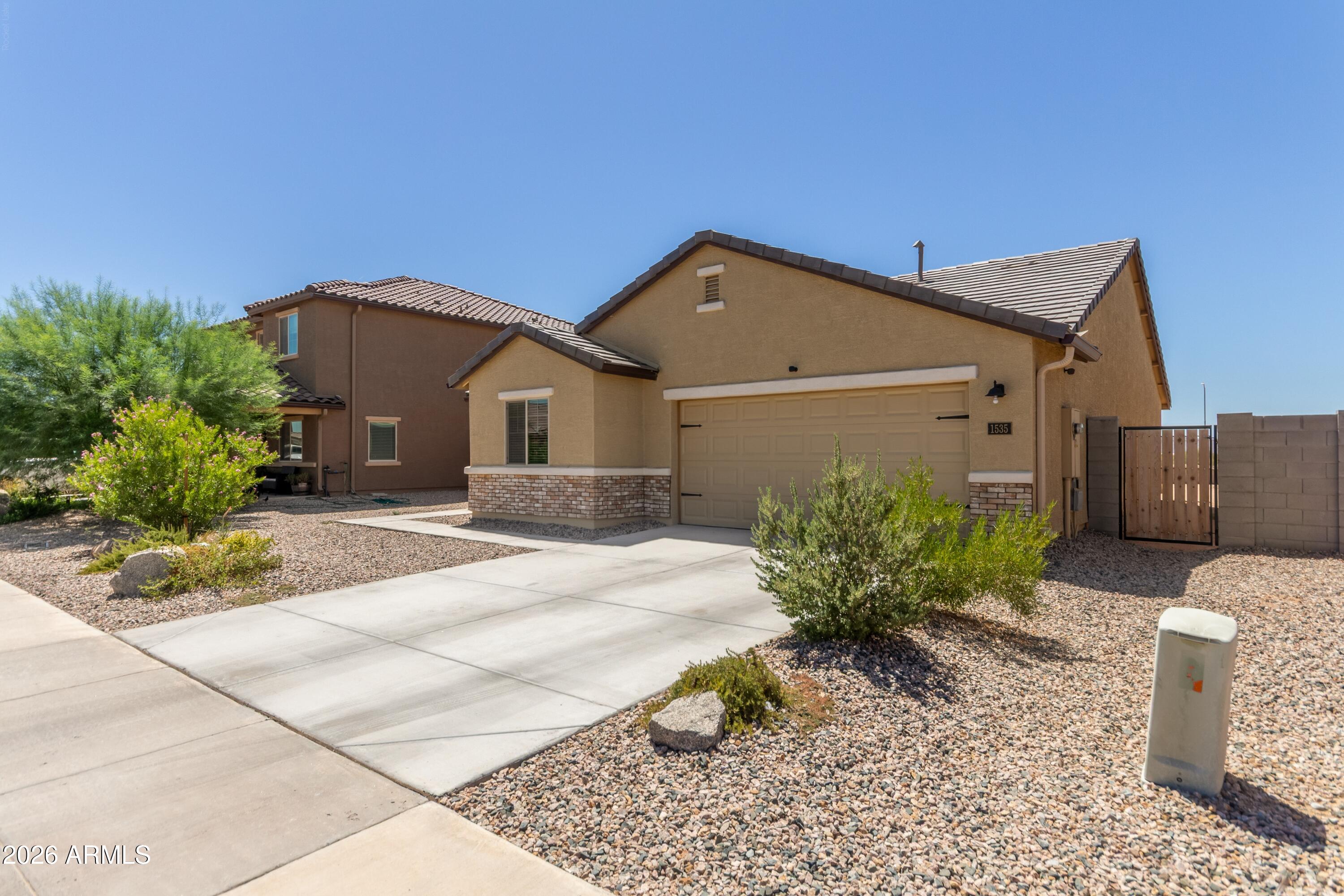 Build your dream backyard! Wake up to stunning mountain views right from your back patio. This charming ranch-style home offers a bright open-concept layout with 3 bedrooms and 2 full bathrooms, including a private primary suite with a walk-in closet. The kitchen shines with granite countertops, rich wood cabinetry with crown molding, and recessed lighting. Enjoy both a welcoming front porch and a covered back patio--perfect for relaxing or entertaining. An oversized insulated garage adds valuable storage space. Conveniently located near I-10 for easy access to Phoenix or Tucson. Well-maintained and move-in ready!