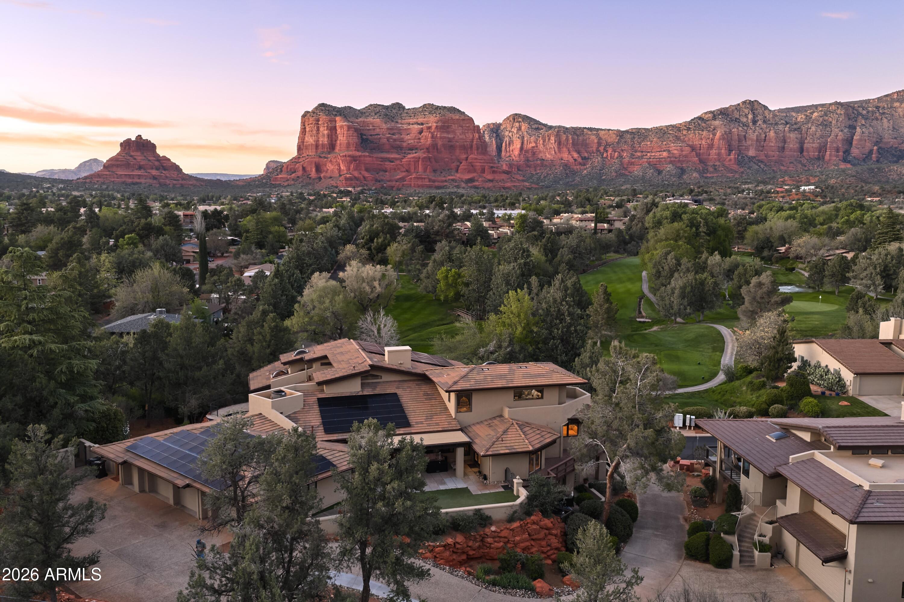 NOTHING ELSE LIKE THIS IN SEDONA. STR FRIENDLY. Reimagined in 2017, this 6,200 SF executive residence at Canyon Mesa Country Club commands sweeping views of Sedona's red rocks, golf course, and Tonto National Forest. Three levels of fully remodeled living, primary suite with direct access to a heated private pool and spa, theater room with bar, private fitness room, and a self-contained mother-in-law suite with its own entrance, garage, and kitchenette. Vaulted ceilings with wood beams throughout. 7 garages, including two full-size RV bays, a workshop, loft, and three additional storage rooms. A 21kW solar system offsets operating costs. HOA covers all exterior maintenance plus unlimited golf, tennis, and pickleball on one of the nation's top-ranked executive courses. GENUINELY MUST SEE.