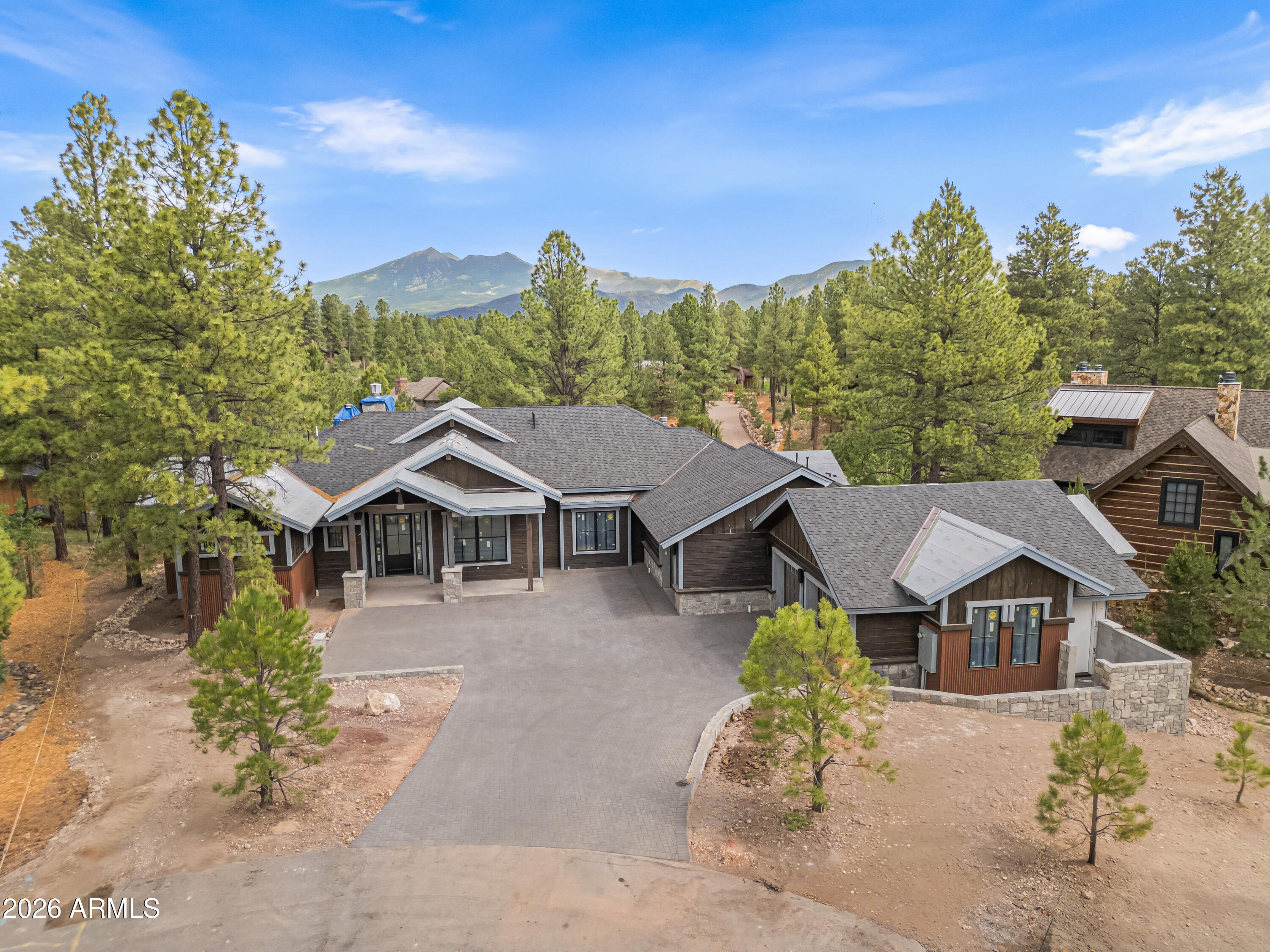 Discover unparalleled refinement and charm in this breathtaking new construction nestled in the heart of Pine Canyon. Tucked at the end of a quiet cul de sac with stunning peak views, this gorgeous mountain retreat features two split-floorplan primary suites on the main level, a sprawling living space with huge compound slider leading to the massive back deck, high end Pella Impervia windows and doors, and so much more! Soaring ceilings create an airy open feel living room, while a sleek linear fireplace anchors the room as a warm and inviting centerpiece. Breathe in the crisp pine air from either the upper deck or lower patio, each appointed with cozy outdoor wood-burning fireplaces. This is a one-of-a-kind expansive estate, boasting almost 10,000 sq ft under roof and 6,169 livable sq ft.