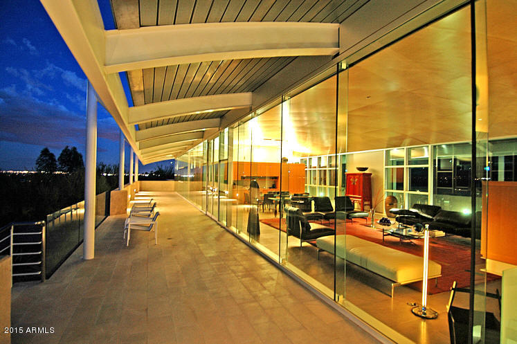 Located on the gently sloping foothills on the North East side of Mummy Mountain, AGRA is a spectacular, timeless and World Class Modern estate. Privately gated on 1.9 acres, the home is a glass box elevated above the desert floor with views of mountains and city lights in every direction. Exquisite and exotic materials crafted by artisans to form a pure modernist home that is both dramatic and warm. The main house features 3 bedrooms, 4.5 baths and a beautiful office and pet grooming facility, while the 3600 sf guest house offers a gracious 3 bedrooms, 2.5 baths and full kitchen, living, family and game rooms.