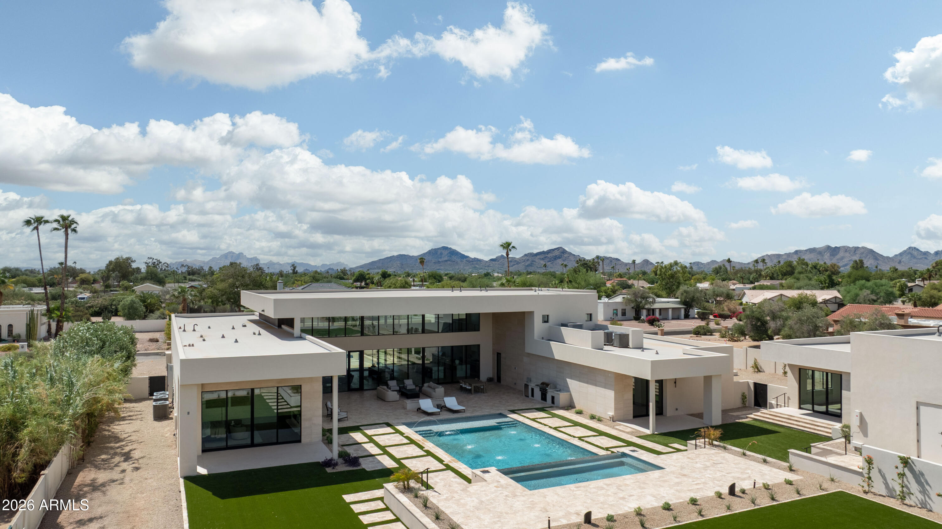 Brand-new 9,000 SF modern estate on 1.1 acres with a standout 7-car garage setup, built for the buyer who actually uses their space. The main residence is paired with a detached guest house featuring its own 3-car garage and private gated entry, creating a true secondary residence for visitors, multi-generational living, or a driver, staff, or security arrangement.

Inside, a thoughtful split floor plan centers on an expansive great room, defined by 24-foot ceilings and walls of glass that open to the resort-style backyard. The chef's kitchen is anchored by a hidden prep kitchen for clean entertaining. The primary suite sits in its own private wing, and a nearby flex space with French doors and a full bath, separated by a striking wine wall, works perfectly a lounge, office, or gym.

Every bedroom offers an en-suite bath for privacy and function. Outside, enjoy a pool, outdoor kitchen and bar, and a full sports court, all designed to match the home's seamless indoor-outdoor flow. Modern architecture, high-end finishes, and move-in ready completion make this one of Scottsdale's rare new-build luxury opportunities, with garage capacity that sets it apart.