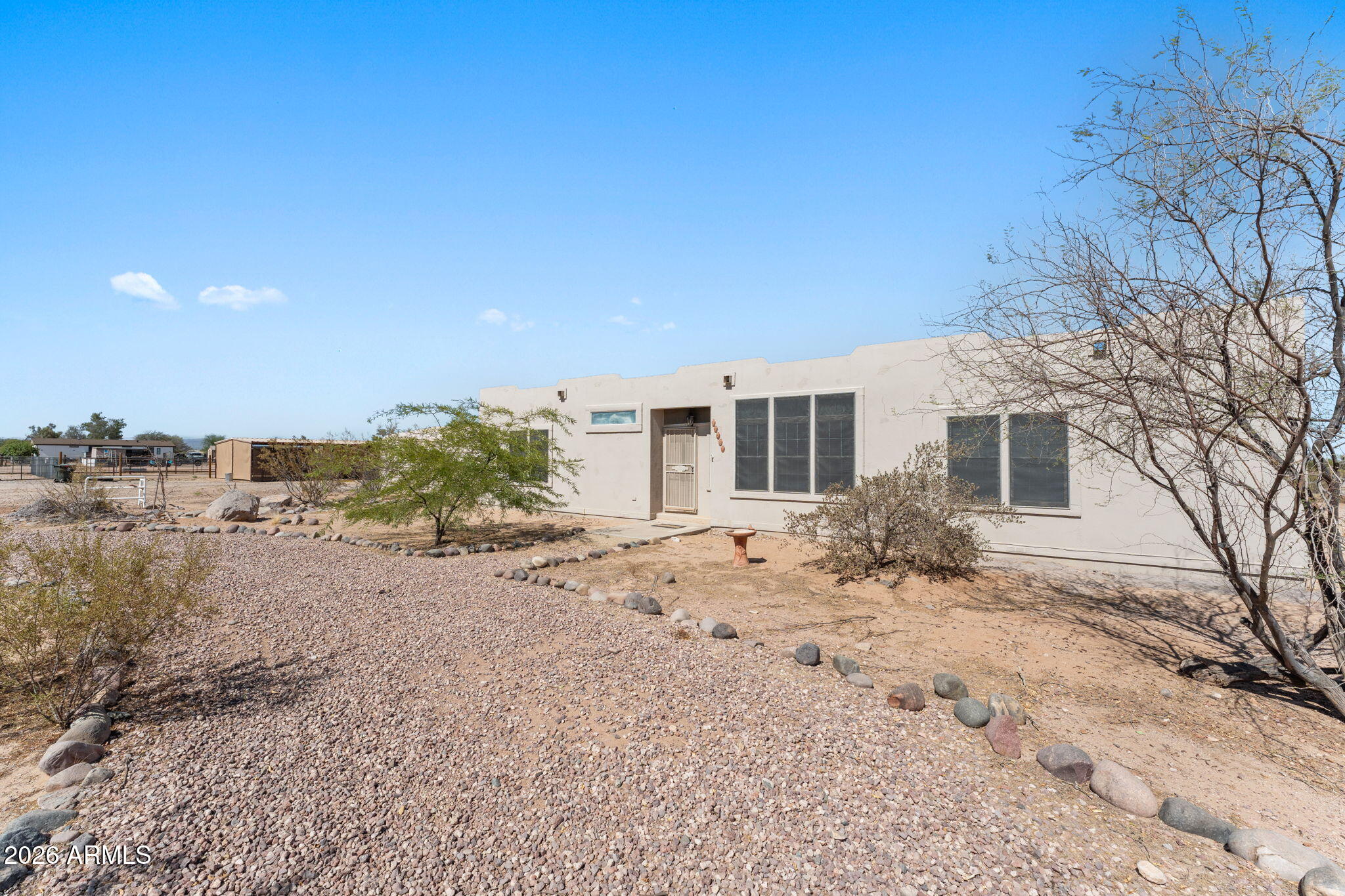 Bring your horses and enjoy the wide-open spaces of Wittmann! Sitting on 1.3 fully fenced acres with stunning White Tank Mountain views, this spacious 1,800 sq. ft. manufactured home offers the perfect blend of comfort, functionality, and horse property living. Featuring a desirable split-bedroom floor plan, this 3-bedroom, 2-bath home boasts a skylight, dual-pane windows, and ceiling fans throughout. The kitchen is equipped with stainless steel appliances, a walk in pantry and opens to the main living areas, creating a welcoming space for everyday living. The oversized primary suite offers a true retreat with dual sinks, a separate soaking tub and shower, and a large walk-in closet. All bedrooms feature walk-in closets, providing abundant storage throughout the home. Recent updates include new carpet in 2023, and the roof resealed in 2021. Outside, horse enthusiasts will appreciate the well-equipped horse setup featuring covered corrals, an arena, wash rack, and tack room. Sellers are also offering the tractor to convey at no additional cost. The property is fully enclosed with no-climb fencing and offers four gated access points for convenience. A covered carport, plenty of RV parking with hookups, and ample room to ride complete this exceptional horse property. Enjoy peaceful country living with room to roam while still being conveniently located near the amenities of Wittmann. A rare opportunity to own a move-in ready horse property with incredible mountain views and all the essentials already in place!
