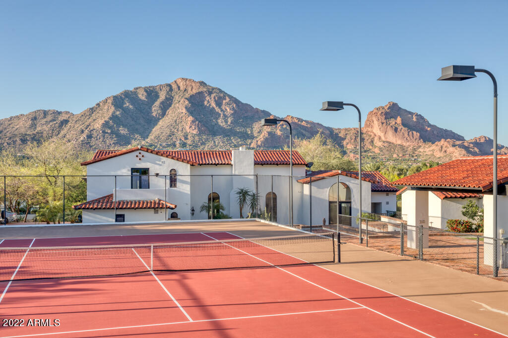 Privately gated w/full Camelback Mtn views & Mummy Mtn views, this Spanish Colonial Revival estate in one of the best areas of Paradise Valley, is in the midst of a renovation. White oak flooring & inlaid stone flooring combine with dramatic 7 ft wide arched hallways and high wood beamed ceilings.The home is very set back from the street and has a huge romantic front courtyard with water feature, BBQ station w/ curved courtyard wall topped with clay tiles. The tranquil backyrd has a tennis court , lawn area & ramada. The main floor has an impressive living/ great rm,dining rm, master bedrm w/fireplace, office or 4th bedroom next to 1of 2 powder rms, kitchen w/catering rm open to family rm next to a game rm w/ large bar. The home currently has 3 bedrms & multiple areas to have a 4th bedrm.