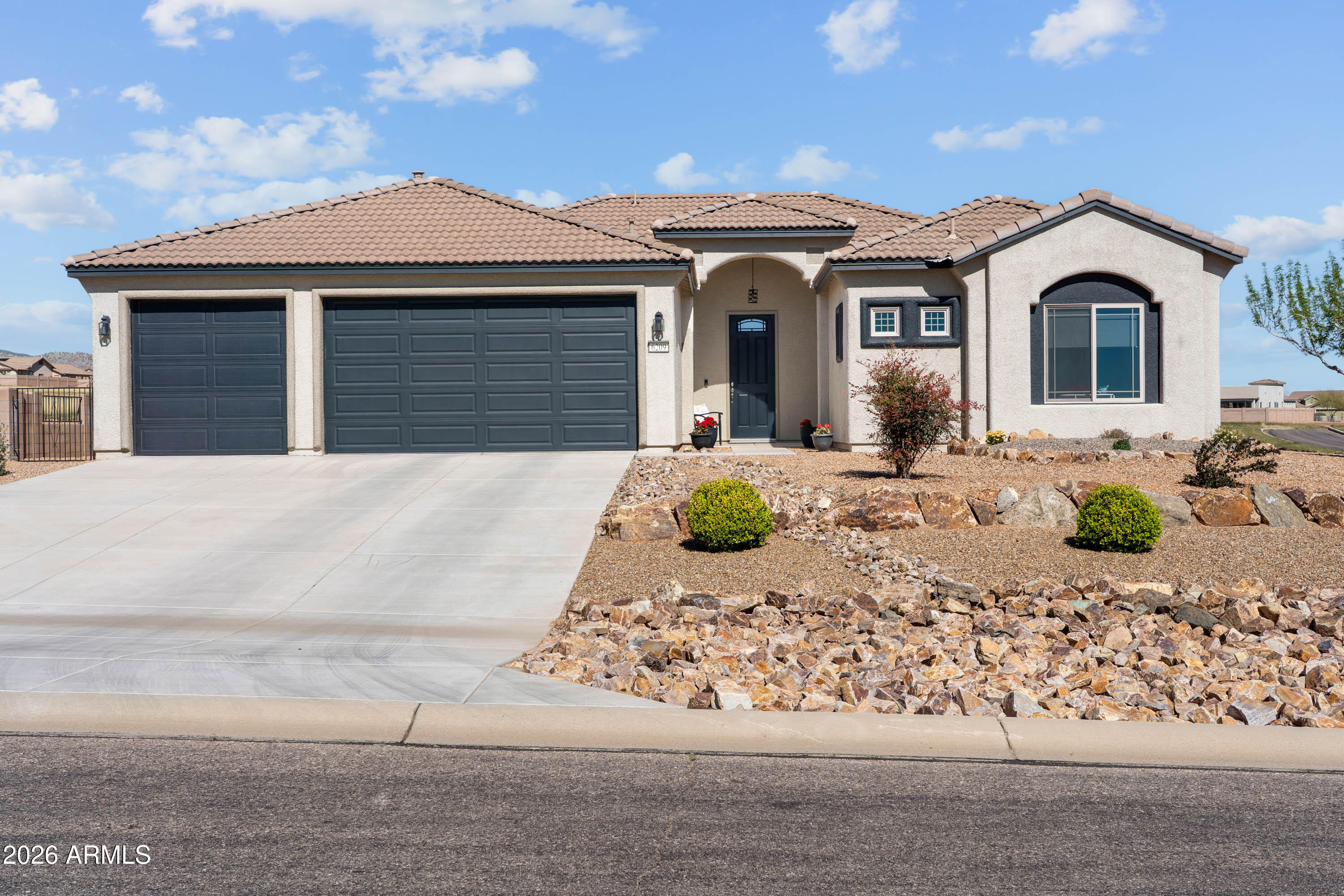 Beautifully maintained corner-lot home with breathtaking mountain views. Inside, the open floor plan features wood-look tile, stylish laminate flooring, upgraded carpet, custom light fixtures, and elegant window treatments throughout. The kitchen is perfect for gathering, featuring granite countertops, white cabinetry, tile backsplash, stainless steel appliances, stylish faucet & finishes, and large breakfast bar with generous seating. The primary suite captures sweeping views and offers an open bathroom, private commode, soaking tub and shower with corner seat and niche, plus a walk-in closet with thoughtful added storage. The garage features epoxy flooring, sink prep, and a water softener. Outside, enjoy the large covered patio, wrought iron view panels, & garden area ready with water.