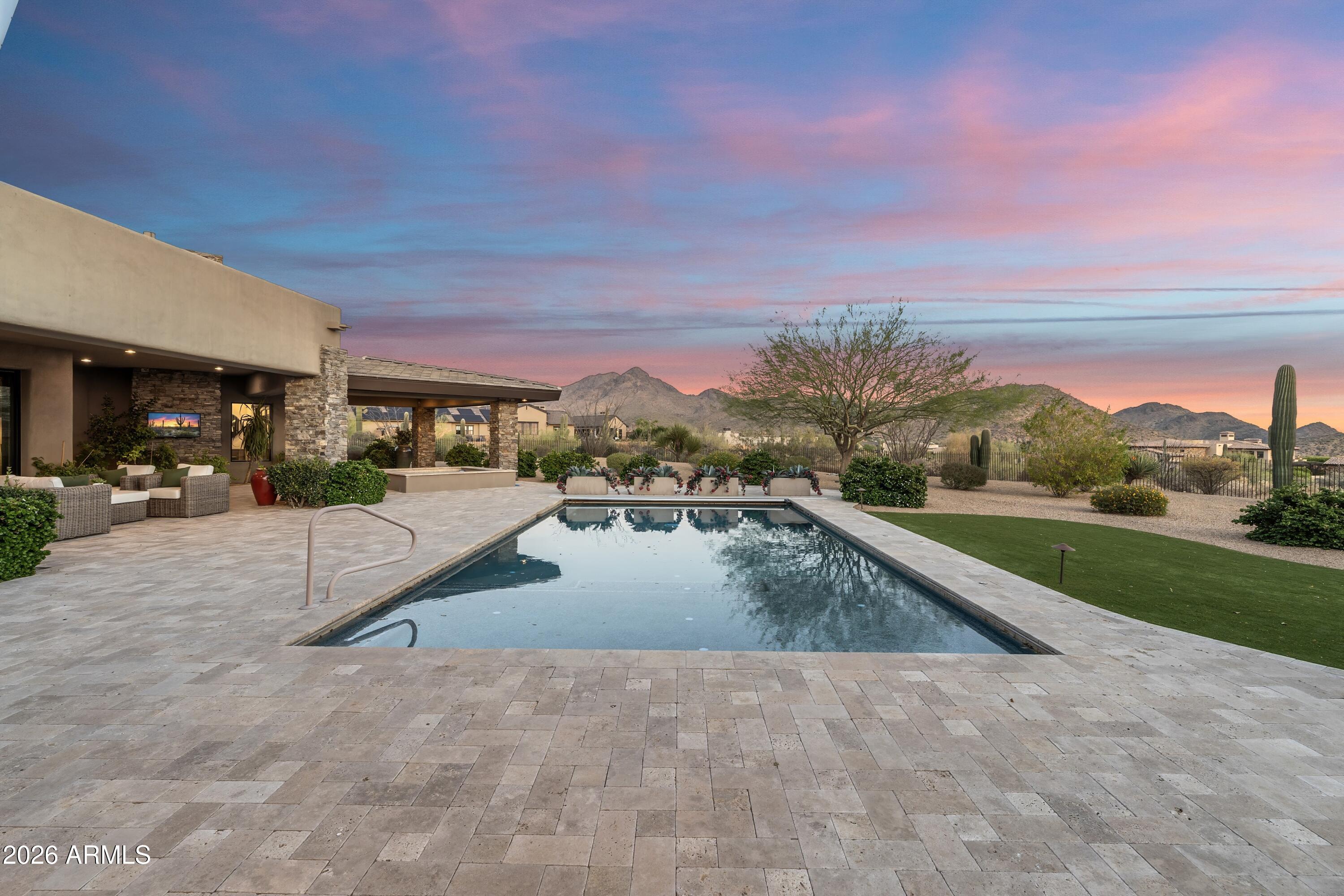Set against a stunning 4.3-acre North Scottsdale backdrop, NO HOA masterclass desert luxury living, framed by panoramic mountain vistas and glittering city light views, for an avid collector. The 6,800-square-foot main residence is designed for both grand-scale entertaining and refined all-in-one level daily living, featuring a magnificent great room, a professional chef's kitchen with a wet bar, and a dedicated (second-level) media/billiard room. The home is thoughtfully tailored for the modern professional with dual executive offices, while the primary sanctuary offers a fireplace, coffee station, and a decadent, spa-inspired bath. The grounds are a paradise for the collector and the host alike, headlined by a massive 12-car/12-ft RV garage Door and a gated motor court. The outdoor oasis features oversized patios, an alfresco kitchen, a heated pool and spa positioned to capture the sunset. Completing this desert compound are TWO detached, fully equipped guest HOMES with private kitchenettes, situated across a charming front courtyard to ensure ultimate privacy for visitors. This is a rare opportunity to own a sophisticated retreat that balances immense scale with intimate, high-end detail.