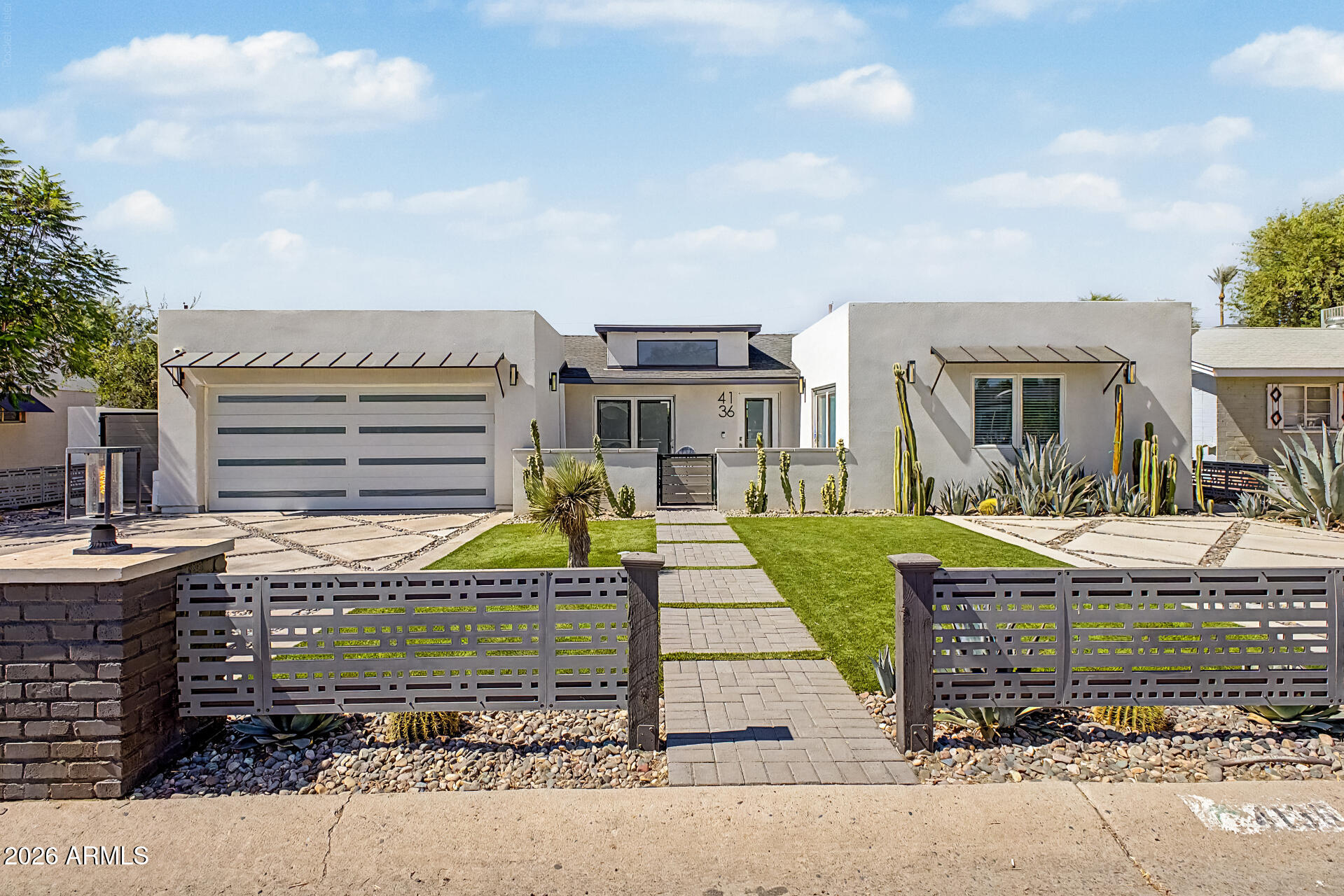 Located in the coveted Arcadia Lite neighborhood and within the highly acclaimed Hopi Elementary, Ingleside Middle, and Arcadia High School district, this exceptional 2022-built contemporary home offers luxury living at its finest. Featuring an open-concept design with soaring ceilings, engineered wood floors, and designer finishes throughout, the home centers around a chef's kitchen with high-end appliances, custom cabinetry, quartz countertops, and a stunning glass wine room. The split floor plan includes a spacious primary suite and three additional bedrooms. Custom glass bifold doors open to a resort-style backyard with a pebble-finish pool, outdoor kitchen, turf, paver patio, retractable awning, and mountain views. A private gated courtyard with gas fire pit and ample street parking.