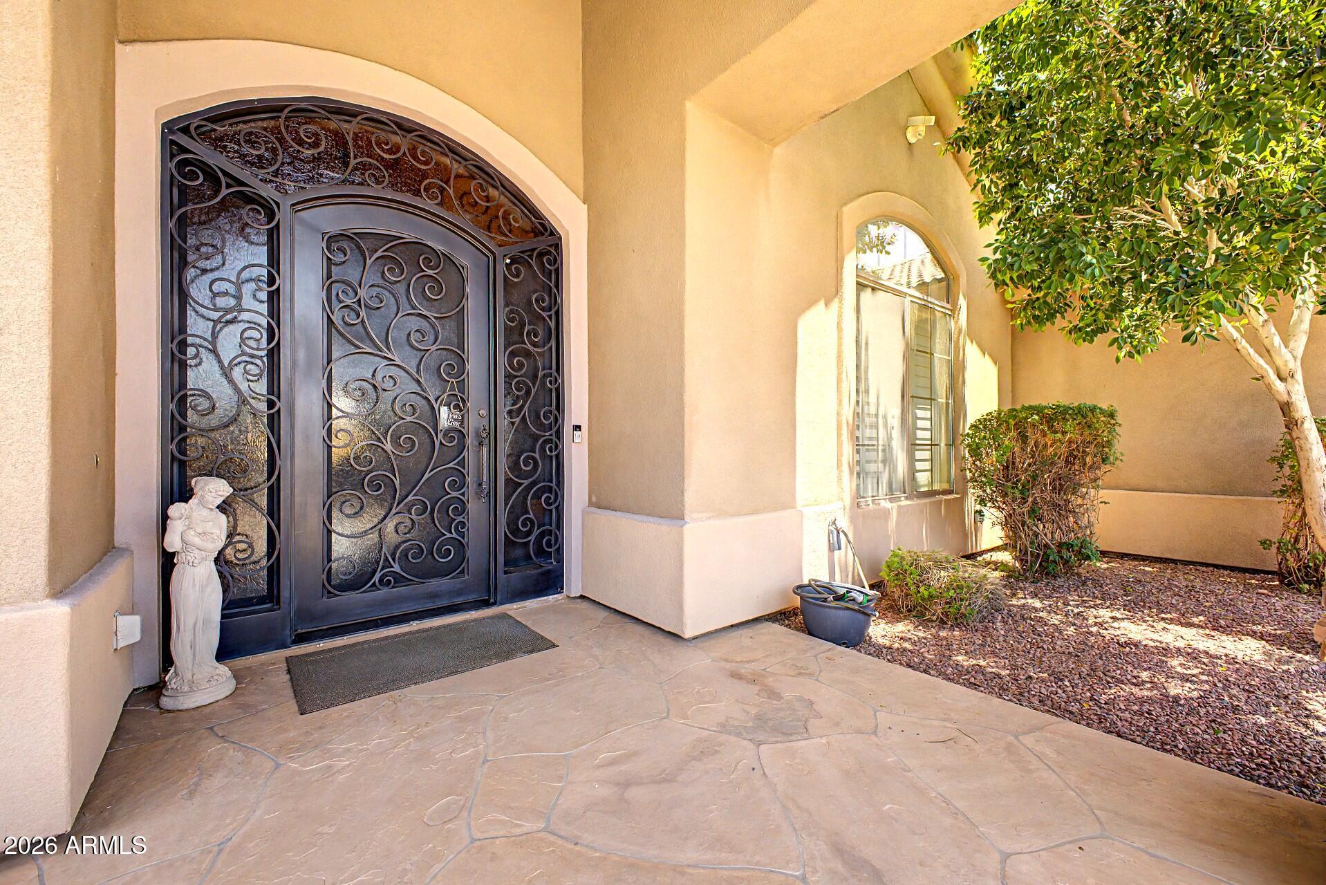 Imagine coming home to your own private resort. Nestled on nearly half an acre within the highly sought-after gated Topaz community, this exceptional single-level estate offers the perfect blend of luxury, comfort, and everyday livability. With 4,215 square feet of beautifully designed living space, this home was built for those who love to entertain, relax, and enjoy the Arizona lifestyle. From the moment you enter, you'll appreciate the spacious open layout, soaring ceilings, abundant natural light, and elegant finishes throughout. The thoughtfully designed floor plan includes 4 generously sized bedrooms, 5 bathrooms, a private executive office, and a separate guest suite that provides privacy and flexibility for multigenerational living, visiting family, or long-term guests. The chef's kitchen is the heart of the home, featuring rich cherry cabinetry, granite countertops, an oversized island, and premium KitchenAid appliances. Whether hosting holiday gatherings or enjoying a quiet evening at home, the open-concept design flows effortlessly into the living and entertaining spaces. Step outside and discover what truly sets this property apart. The backyard is a private retreat designed for year-round enjoyment, complete with a heated Pebble Tec pool, waterfall grotto, spa, expansive travertine decking, outdoor fireplaces, and a built-in BBQ. It's the perfect setting for sunset dinners, weekend pool parties, or simply unwinding after a long day. Additional features include a rare 4-car garage, RV gate, central vacuum system, surround sound, two marble fireplaces, plantation shutters, skylights, and fully owned SolarEdge® solar panels for energy efficiency and long-term savings. Luxury homes offer features. Exceptional homes create experiences. This is one of them. Your private tour awaits! Experience the lifestyle for yourself.