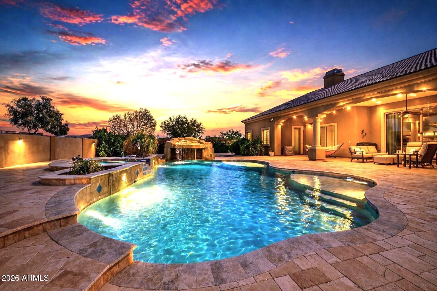Imagine coming home to your own private resort. Nestled on nearly half an acre within the highly sought-after gated Topaz community, this exceptional single-level estate offers the perfect blend of luxury, comfort, and everyday livability. With 4,215 square feet of beautifully designed living space, this home was built for those who love to entertain, relax, and enjoy the Arizona lifestyle. From the moment you enter, you'll appreciate the spacious open layout, soaring ceilings, abundant natural light, and elegant finishes throughout. The thoughtfully designed floor plan includes 4 generously sized bedrooms, 5 bathrooms, a private executive office, and a separate guest suite that provides privacy and flexibility for multigenerational living, visiting family, or long-term guests. The chef's kitchen is the heart of the home, featuring rich cherry cabinetry, granite countertops, an oversized island, and premium KitchenAid appliances. Whether hosting holiday gatherings or enjoying a quiet evening at home, the open-concept design flows effortlessly into the living and entertaining spaces. Step outside and discover what truly sets this property apart. The backyard is a private retreat designed for year-round enjoyment, complete with a heated Pebble Tec pool, waterfall grotto, spa, expansive travertine decking, outdoor fireplaces, and a built-in BBQ. It's the perfect setting for sunset dinners, weekend pool parties, or simply unwinding after a long day. Additional features include a rare 4-car garage, RV gate, central vacuum system, surround sound, two marble fireplaces, plantation shutters, skylights, and fully owned SolarEdge® solar panels for energy efficiency and long-term savings. Luxury homes offer features. Exceptional homes create experiences. This is one of them. Your private tour awaits! Experience the lifestyle for yourself.