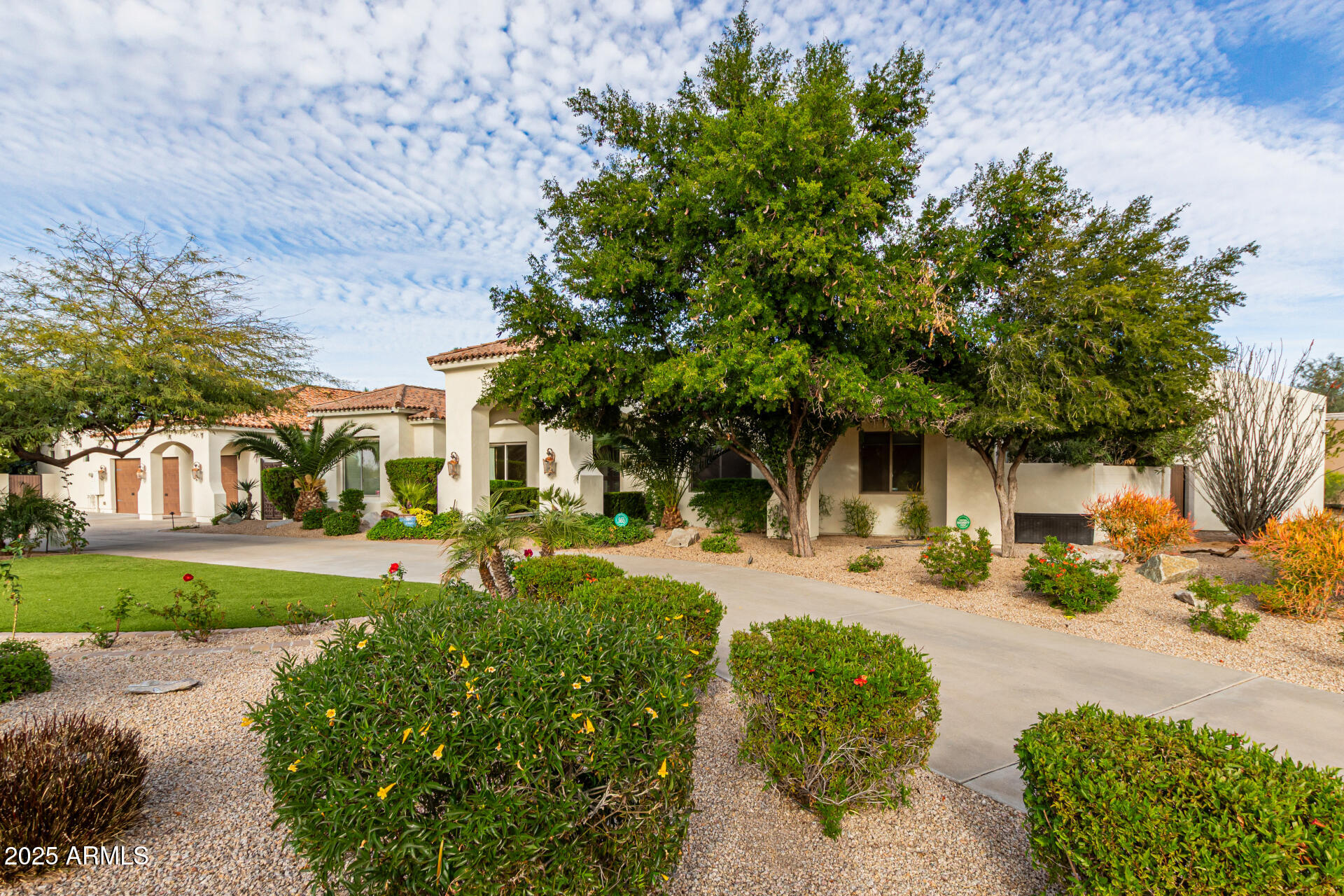 Plenty of room for the whole family! This Santa Barbara-style estate offers tons of space and charm - conveniently located just minutes to Old Town or Kierland/ SQ. Situated on a prime corner lot, this 7-bedroom, 6-bath, 6,945 sq ft residence features arched doorways, soaring ceilings, and rich traditional details throughout. Designed with multiple living areas, wet bars, and an in-home theater, this residence comfortably accommodates a large family or multi-generational living. The expanded primary suite is a true retreat with dual wings - one offers a custom walk-in closet with washer/dryer, soaking tub, dual vanities, and a private bidet room. The other wing includes a massive steam shower, bidet, wet bar, walk-in closet, and a private office/lounge with direct backyard access. The open-concept main living room with fireplace flows into a charming breakfast nook and formal dining room with exposed beams, while the chef's kitchen offers a Sub-Zero refrigerator, double ovens, gas cooktop and pot filler.  Outside you will find a resort-style backyard oasis, complete with a diving pool, fire pit, Alfa pizza oven, outdoor kitchen, above-ground spa, lush landscaping, synthetic turf, multiple covered patios, and a ½ basketball court perfect for entertaining year-round. Ideally located near freeways, premier shopping, dining, this exceptional estate offers the perfect blend of space, privacy, and sophistication.