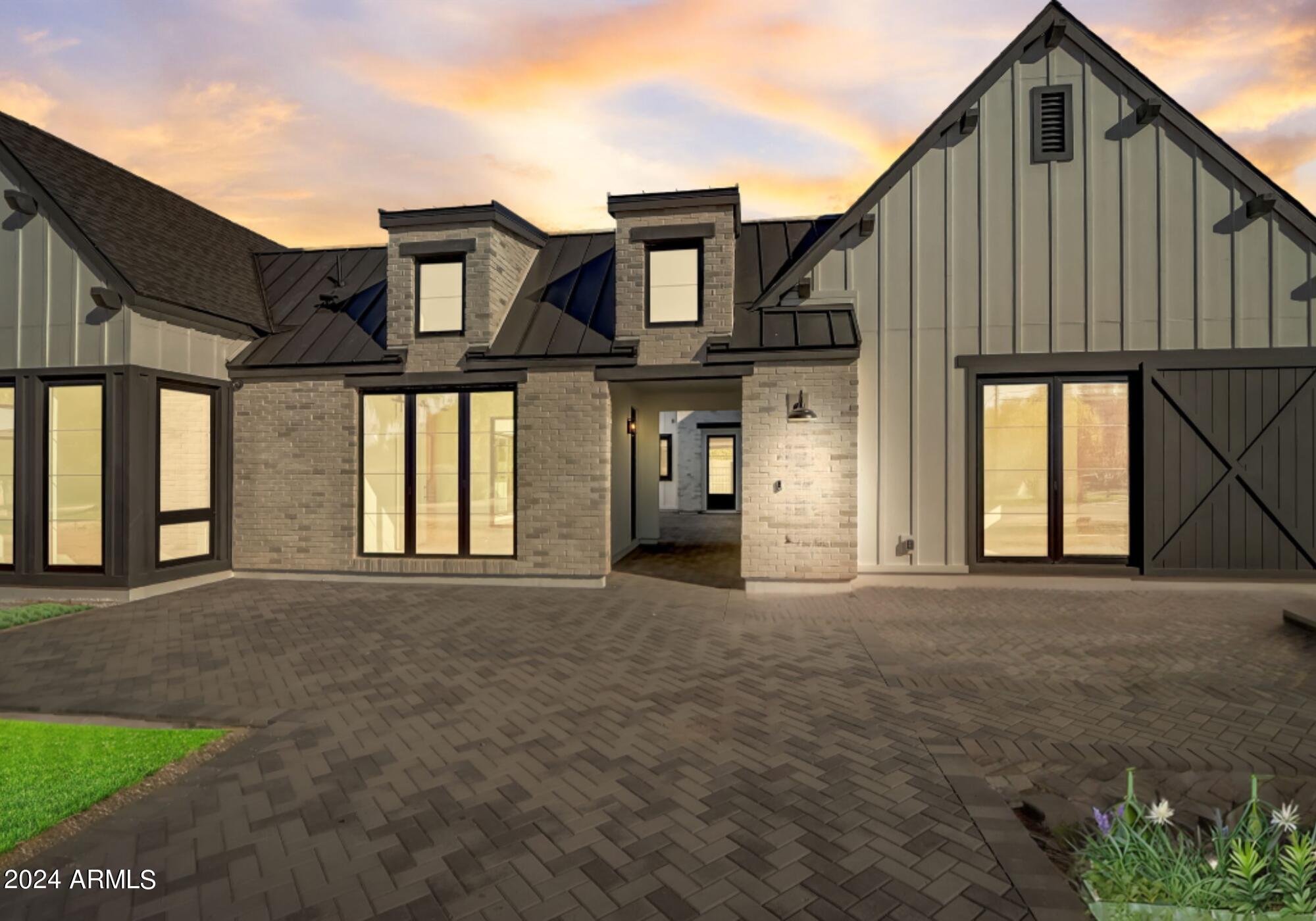 This stunning NEW build by Thomas James Homes is ALMOST complete! Move in before the holidays! We have added some show stopping features to this home! This exquisite 5-bedroom, 5.5-bathroom modern farmhouse offers an unparalleled blend of sophisticated design and superior craftsmanship. As you step inside, you're greeted by wide plank European Oak hardwood floor and captivating ceiling and wall treatments, including light walnut beams and wood paneling. Custom lighting accents every space, highlighting the impeccable millwork, stone, and tile details throughout. A striking floor-to-ceiling El Dorado Tundra brick chalk dust fireplace. The heart of the home boasts a spacious great room and a gourmet kitchen, complete with SUBZERO and WOLF appliances, a large quartz countertop island, matte black island pendants, castle brick white herringbone backsplash, maple range hood and shaker repose gray cabinetry. The luxurious grand suite features a generous walk-in closet with upgraded built ins and a spa-like bathroom with a freestanding soaking tub and walk-in shower. Each additional bedroom enjoys the convenience of an en-suite bathroom. Beyond the bedrooms, find added comfort and versatility with a private office, gym, and a kitchen prep area adjoining a generous bonus room. Outside, the fully landscaped front and back yards feature a sparkling pool and spa, ideal for enjoying Arizona's outdoor lifestyle. Conveniently located just minutes from top-rated dining, shopping, and entertainment, this home offers the epitome of luxury living in a prime Scottsdale location.