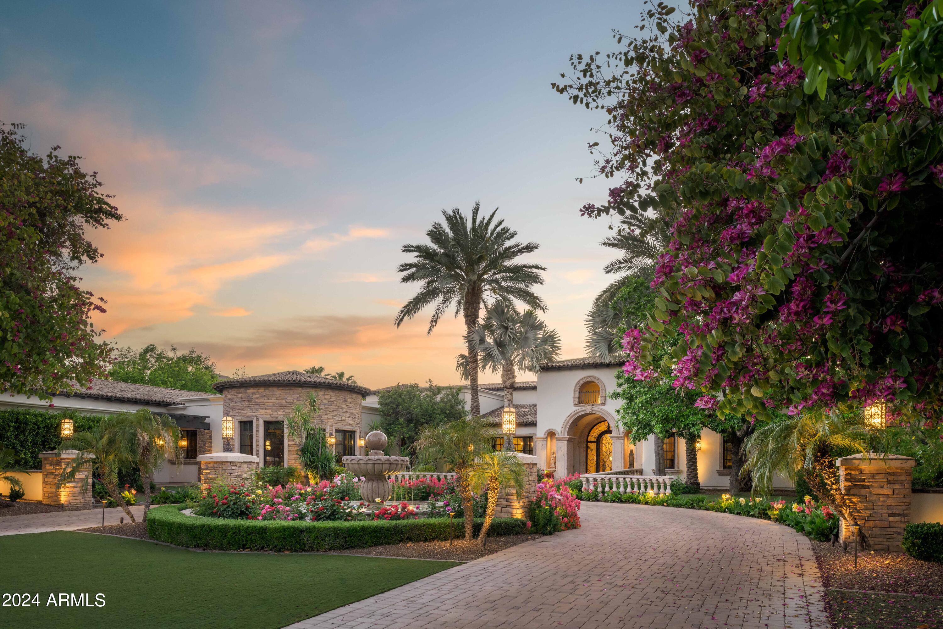 Discover an exclusive opportunity to own a prestigious estate in the highly sought-after Judson Estates of Paradise Valley. Set on a sprawling 1.5-acre lot, this magnificent property offers breathtaking mountain views and an expansive living space exceeding 11,000 square feet, which includes a private guest casita and a separate guest house. Upon arrival, be greeted by a grand circular driveway, meticulously landscaped to perfection. Enter through the impressive front doors to be welcomed by stunning vistas of the resort-style backyard and pool. The covered patio, designed for exceptional entertaining, features an outdoor kitchen, extensive covered seating areas, and serene fountains that enhance the tranquil ambiance. The gourmet kitchen is an entertainer's dream, while the elegant dining room, complete with a private bar and wine cellar, exudes sophistication. The living room features another bar and seamlessly opens with a wall to wall pocket door to the resort-style backyard, creating a perfect blend of indoor and outdoor living. The luxurious primary suite boasts a thoughtfully designed split floor plan, two opulent closets, a private workout room or sitting area, extra storage, and exclusive patios. Guests will enjoy their stay in the private attached casita, which boasts a spacious living area and a full kitchen. For added privacy, the separate guest house offers additional luxurious accommodations apart from the main home. An oversized five-car garage, complete with a spacious recreation room, provides ample additional space. Indulge in the epitome of luxury living with this exquisite estate in Judson Estates.