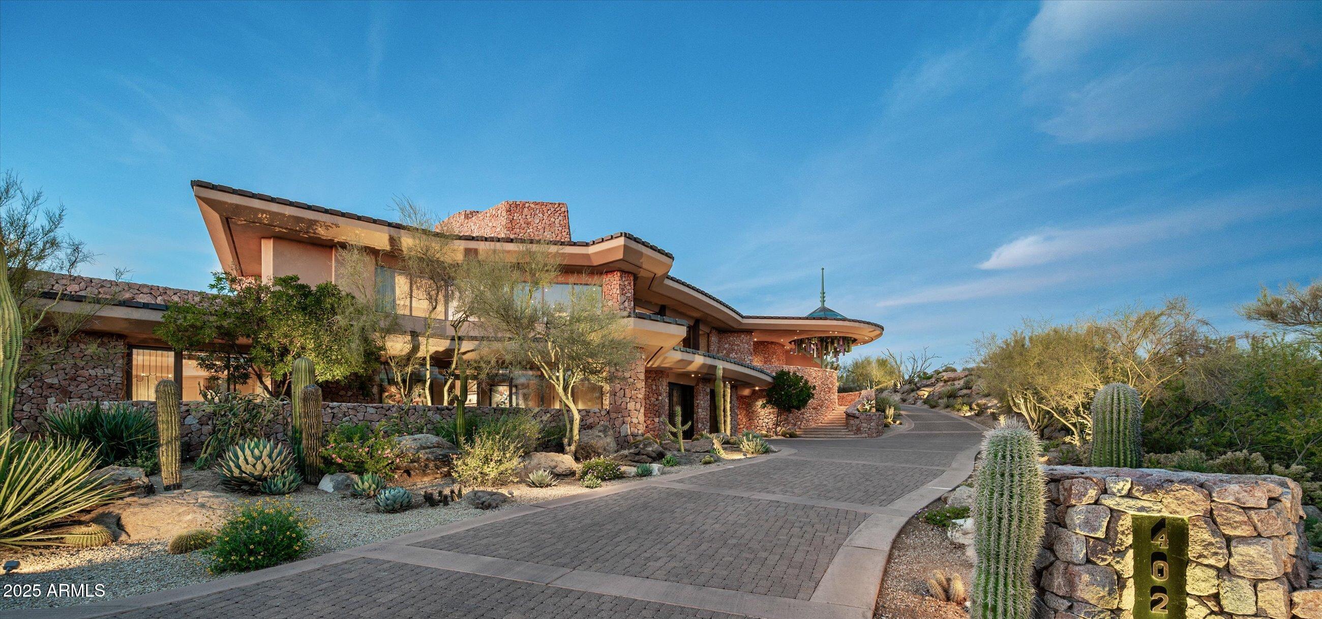 Golf membership available!  Discover a one-of-a-kind estate that redefines luxury living with extraordinary architecture by renowned architect Vernon Swaback. Inspired by the timeless principles of Frank Lloyd Wright, this masterfully crafted home seamlessly blends organic materials and open spaces, creating seamless indoor/outdoor living. Spanning 9,074 square feet across a premier golf course lot on 2.35 acres, this 4 bed, 4 full baths, and 3 half baths estate offers an expansive great room, dining room, office, fitness room, family room, wet bar, workshop, attached casita with full kitchen, and 5 car garage. Step outdoors to your desert oasis, an awe-inspiring negative edge pool, spa, built-in BBQ, and multiple patios overlook the manicured fairways, creating a tranquil retreat. Home is offered furnished with exceptions.
