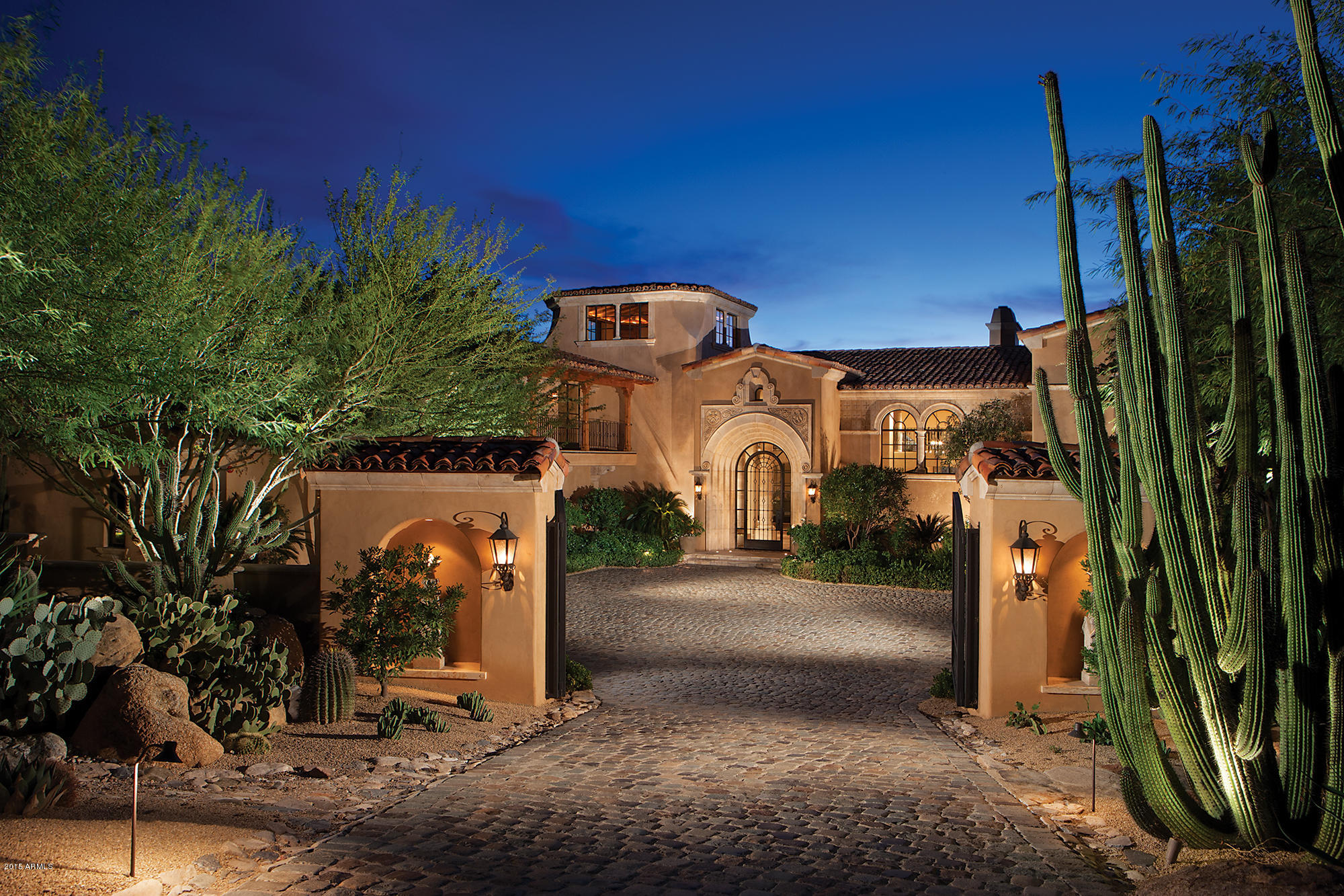This magnificent Silverleaf Upper Canyon estate is situated on a very private 2 acre setting behind the 7th tee box overlooking breathtaking city light and mountain views. This impeccably built home has been put in perfect condition and is now for sale for a fraction of its original $13M building cost. It is loaded with numerous luxury and imported features and finishes. You enter the property through its own private gated  driveway of reclaimed cobblestone pavers. The massive iron entry door opens to an entry hall overlooking an elegant and grand living room with  its oak floors magnificent fireplace and stunning walls of hand forged iron framed windows. Only the finest imported interior finishes have been used including French limestone, “Scrumpy Jack” oak wood flooring, Turkish custom-made columns, detailed oak coffered ceilings and a two story office and library with hand-carved pine wood paneling. The kitchen showcases rich furniture quality cabinetry, the highest quality appliances, imported pewter countertops, a spacious butler's pantry and a kitchen-office. A spacious family room with fireplace adjoins the kitchen. The master suite features a private serenity garden, exercise room and a lavish bathtub carved out of a single block of Turkish limestone. The limestone staircase and upper walkway is highlighted with custom Rob Gunter iron railings that leads to the guest suites and a lookout tower offering amazing 360 degree views of the mountain preserve, golf fairways, and city lights. The lavish two room guest house is a short walk along a brick pathway through a desert garden. Over 2 million dollars was invested in the landscaping that is highlighted by lush plantings, walkways, gardens, fountains, barbecue, pool, spa and patios that achieve a balance of privacy while maintaining spectacular views.