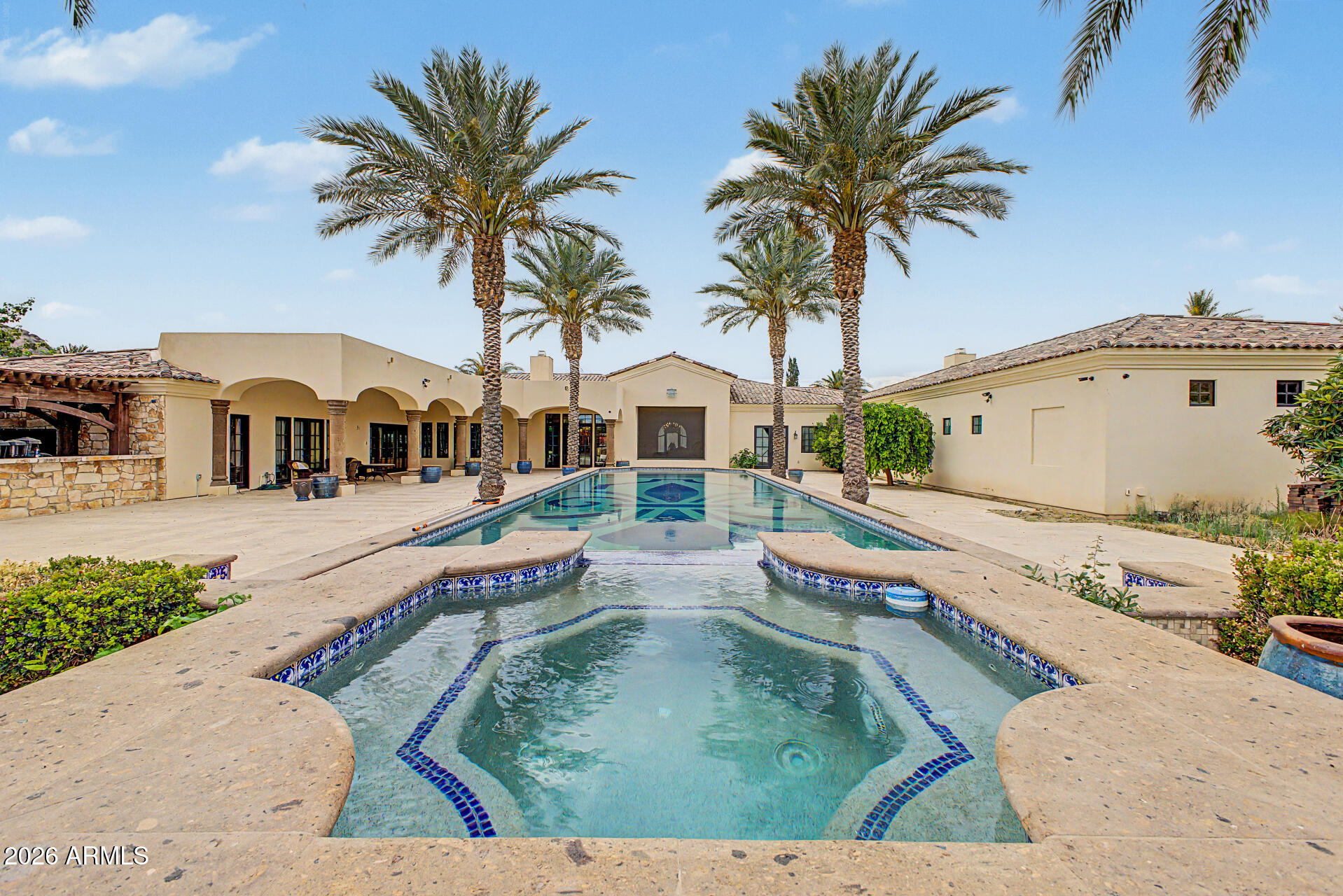 Nestled in the heart of Paradise Valley on 1.27 acres, this nearly 9,800 sq ft estate offers 6 bedrooms, 6 full and 2 half baths, blending luxury with thoughtful design. The expansive layout features a massive chef's kitchen with dual islands, gas cooktop, and double ovens, opening seamlessly to elegant living spaces with stunning Camelback Mountain views. The private master wing includes dual closets, vanities, toilets, a steam shower, and direct access to a rare indoor lap pool. Outdoors, enjoy a resort-style pool and spa. Complete with a 4-car garage, this home delivers exceptional comfort, privacy, and premier location living. privacy, a large walk-in closet for effortless organization, and an elegant bathroom with a separate shower & tub. The large office displays beautiful coffered ceilings and walls, with built-in shelving, making it perfect for a study room or workspace. Step outside to find your backyard oasis, featuring abundant seating space with travertine pavers, an expansive covered patio perfect for entertaining, a built-in BBQ, a relaxing spa, and a sparkling pool. This home is beautifully designed to be a paradise for you and your loved ones, offering the perfect blend of luxury, modern comfort, privacy, and mountain views. Just WOW!