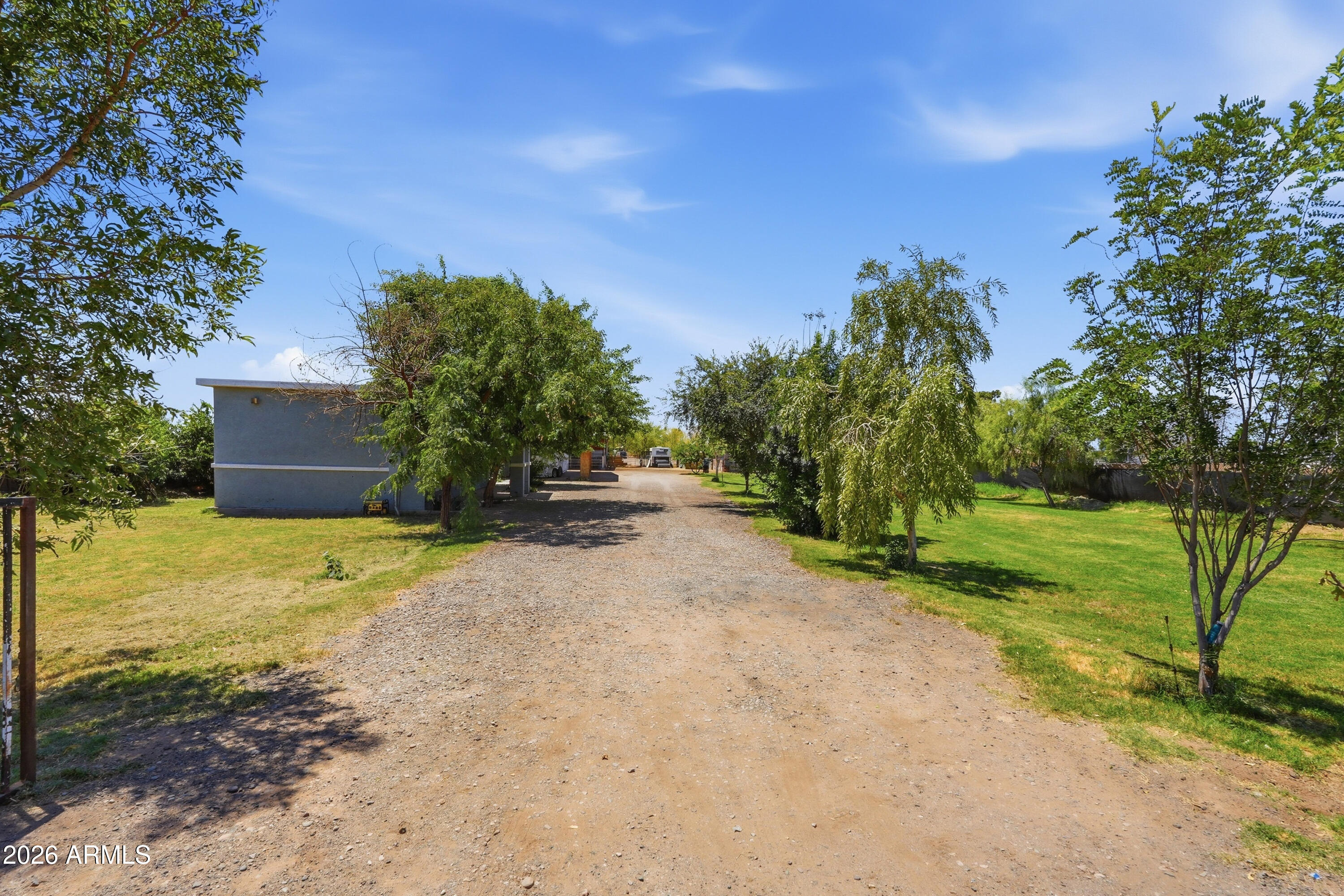 Prime investment opportunity in a rapidly expanding area just one mile from Loop 303. This irrigated property offers exceptional versatility and future potential with existing horse corrals, water on-site, and a structure suitable for office or workspace use. Ideal for investors, contractors, fleet parking, equestrian operations, storage, or business use with ample space for trucks, trailers, equipment, and commercial vehicles. Convenient freeway access and flexible utility make this property well-positioned for growth in a high-demand corridor..