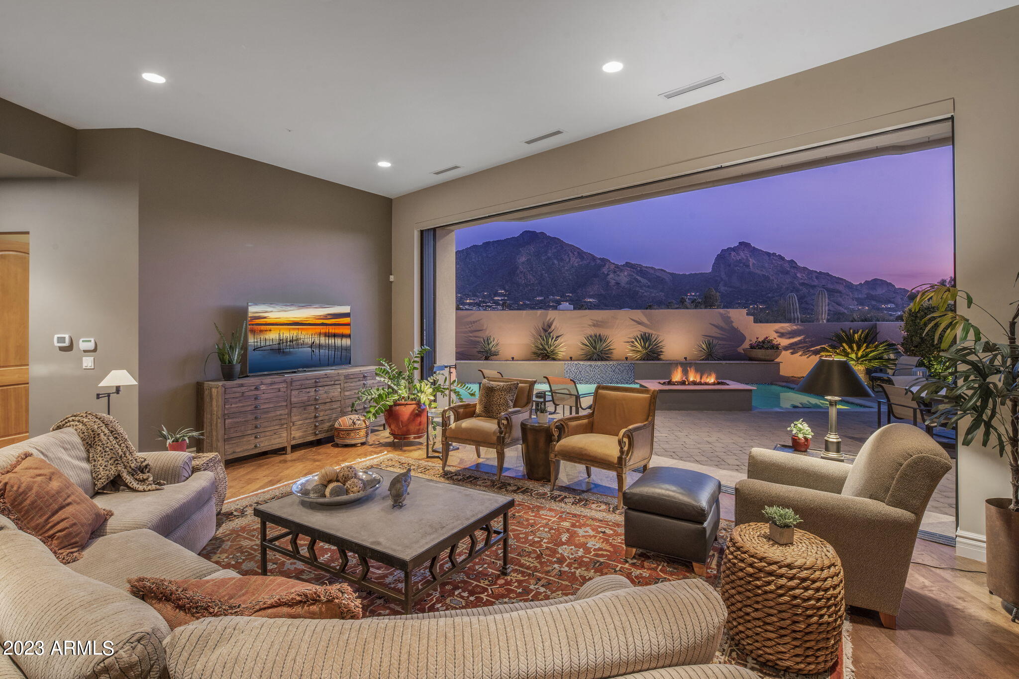 The most captivating setting awaits from coveted guard gated Colonia Miramonte, in the heart of Paradise Valley with 360 degree views of Camelback and Mummy Mountain. Enter the private courtyard past the fireplace & full casita, through the glass pivot door where Camelback is perfectly framed as the focal point for the main living space.  Soaring ceilings & hardwood floors span the interior creating a feeling of casual elegance throughout. Automated glass pocket sliders lead to the pool area & outdoor fire pit where you can enjoy endless sunrises to the east & sunsets to the west night after night with a glass of wine & dinner from your built in grill or outdoor pizza oven.  The kitchen is timeless with custom cabinetry, a Wolf Range, large center island and an immense walk in pantry.  Retreat the spacious primary suite with its wood beamed ceiling and cozy fireplace.  The spa like bath has dual vanities, a soak tub, walk-in glass shower and the ideal walk-in closet.  The secondary bedroom and office are equally spacious while the guest casita off the courtyard offers even more flexibility. The yard is unique with privacy and lush landscape along with endless views. Order room service or walk to the adjacent Camelback Inn for a change of scenery or evening way from home.